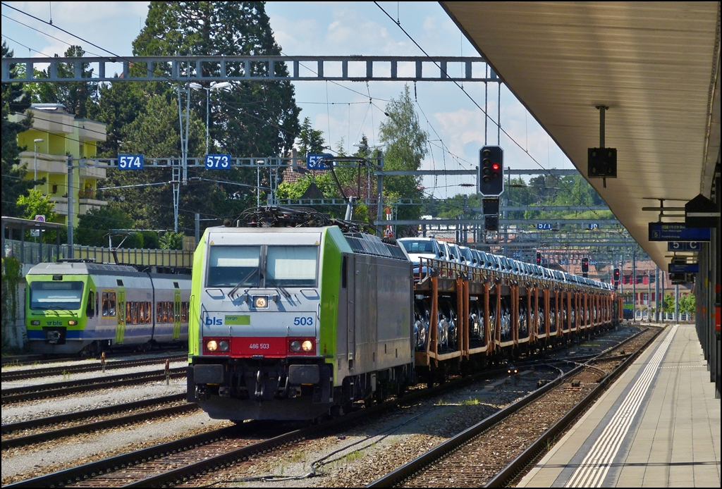 - BLS Farben mit einem Tupfer Rot - Die BLS Cargo 486 503 durchf�hrt mit einem Autozug den Bahnhof von Spiez, w�hrend sich hinten der BLS NINA N� 12 versteckt. 28.05.2012 (Hans)