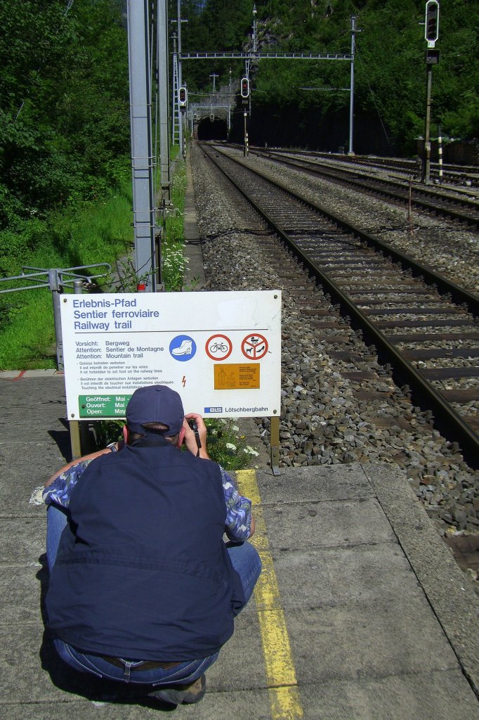 Auch in Zugpausen: immer auf der Suche nach Motiven. Mein Bruder fotografiert ein Hinweisschild zum Erlebnis-Pfad des BLS-Wanderweges entlang der L�tschberg Nordrampe am Bahnhof Blausee-Mitholz.(04.08.2007)
