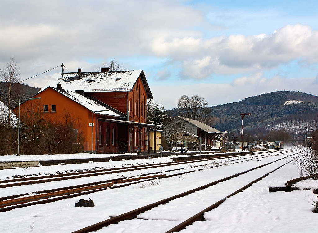 Blick auf den Bahnhof Herdorf am 09.02.2013. 
Vorne das ehem. Empfangsgeb�ude, rechts davon der ehem. G�terschuppen und ganz hinten im Bild rechts das Stellwerk Herdorf Ost (Ho). 
Ein Stadler GTW 2/6 der Hellertalbahn kommt von Neunkirchen und f�hrt gerade in den Bahnhof ein. 
Den GTW wollte ich hier eigentlich vor dem Bahnhof ablichten, aber aufgrund der n�chtlichen neuen Farbgebung (Schmierereien) musste ich darauf verzichten
