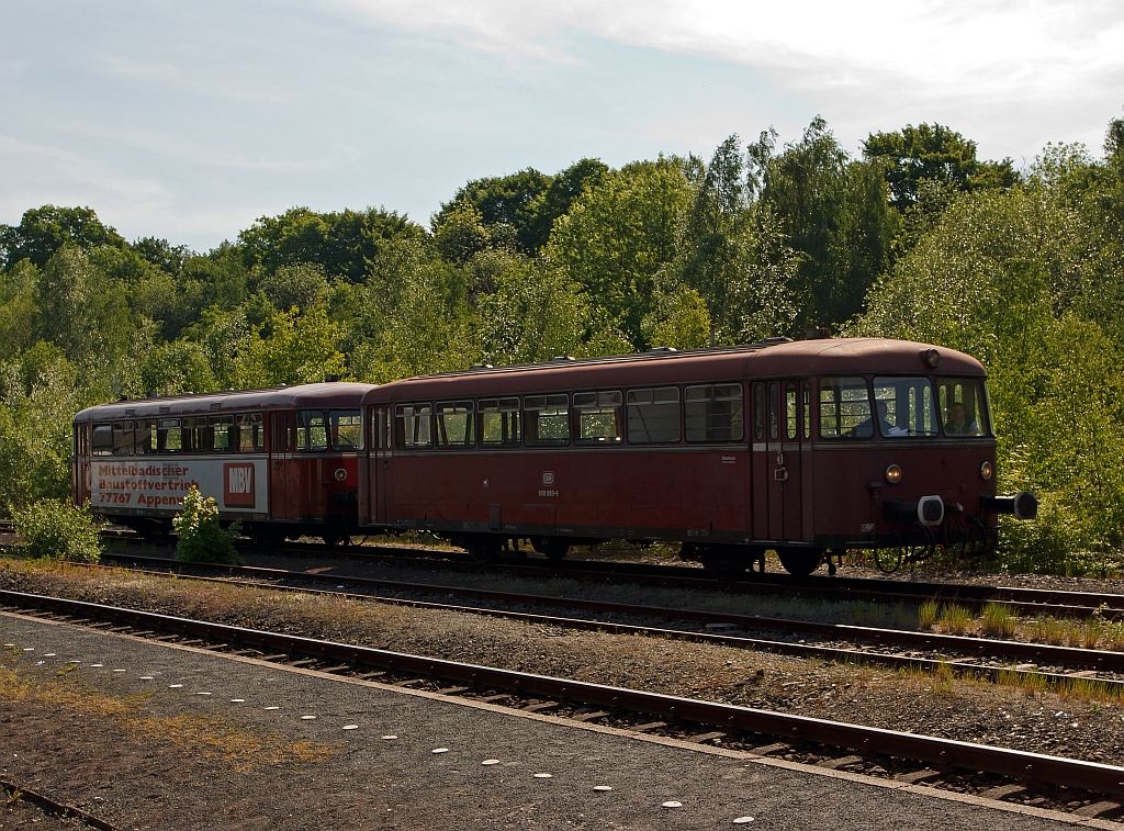 Da kommt er ja (im leicten Gegenlicht): Der Schienenbus 798 818-1 (Pfalzbahn) mit Beiwagen 998 880-9 f�hrt auf Gleis 3 in den Bahnhof Herdorf am 08.05.2011, hier hat er erstmal Hp0 und muss die Hellertalbahn abwarten. Eigentlich sollte er schon den Sonderfahrplan fahren, aber er war etwas versp�tet. Die Oberhessischen Eisenbahnfreunde fuhren sp�ter Sonderverkehr f�r die Hellertalbahn.
Der VT wurde 1962 bei MAN N�rnberg unter der Fabriknummer 146600 gebaut, der VS 1959 bei WMD Donauw�rth unter Fabriknummer 1412.
