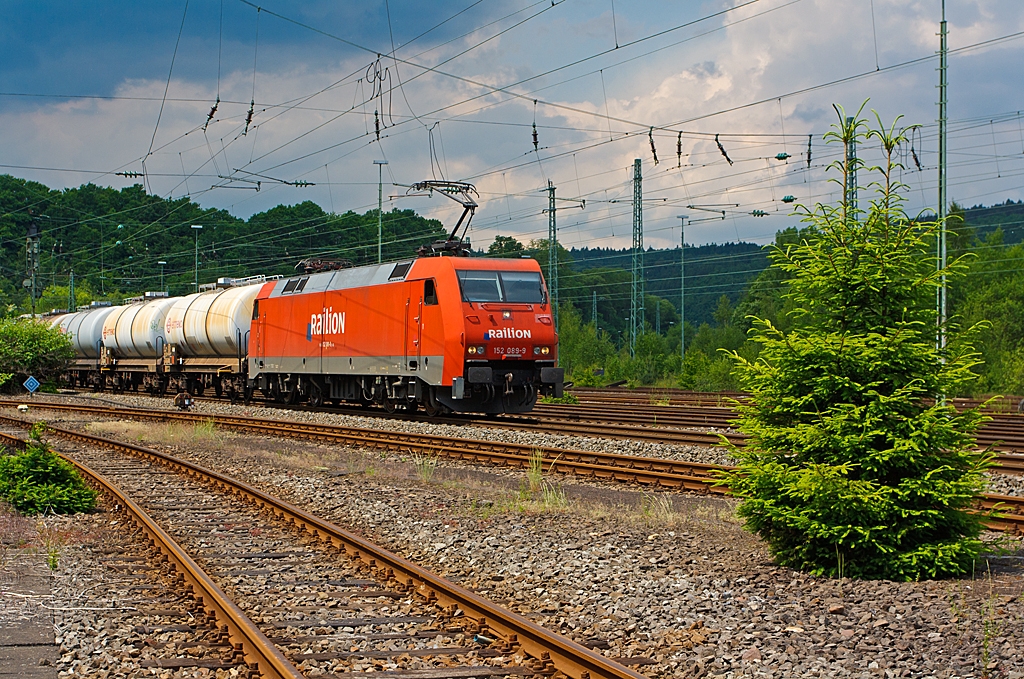 Die 152 089-9 der DB Schenker Rail Deutschland AG mit einem Kesselwagenzug, f�hrt am 08.06.2013 auf der Siegstrecke (KBS 460) in Richtung Siegen, hier kurz vor dem Bahnhof Betzdorf (Sieg).
Die Lok wurde 1999 bei Krauss-Maffei (heute Siemens) unter der Fabriknummer 20216 gebaut, sie hat aktuelle NVR-Nr.  91 80 6152 089-9 D-DB und die EBA 96Q15A 089.

Die Baureihe 152
Als Ersatz f�r die schweren E-Loks der BR 150 und f�r Einsatzgebiete der BR 151 / 155 wurde die Beschaffung der Drehstromlok der BR 152 (Siemens ES64F) eingeleitet, sie ist eine Hochleistungslokomotive aus der Siemens ES64 EuroSprinter-Typenfamilie f�r den schweren G�terzugverkehr, die auch f�r Personenz�ge genutzt werden kann.

Die Baureihe basiert auf dem von Siemens konstruierten Prototyp ES64P. Da jedoch klar war, dass die Maschinen ausschlie�lich im G�terverkehr eingesetzt werden sollten und eine H�chstgeschwindigkeit von 140 km/h als ausreichend angesehen wurde, konnte auf die Verwendung von voll abgefederten Fahrmotoren verzichtet und auf den wesentlich einfacheren und preisg�nstigeren Tatzlager-Antrieb zur�ckgegriffen werden. Dieser gilt durch die Verwendung moderner Drehstrommotoren bei niedrigen Geschwindigkeiten als relativ verschlei�arm.

Technische Daten der BR 152:
Achsformel: Bo´Bo´
L�nge �ber Puffer: 19.580 mm
Breite: 3.000 mm
Drehzapfenabstand: 9.900 mm
Drehgestellachsstand: 3.000 mm
Dienstmasse: 86,7 t
H�chstgeschwindigkeit: 140 km/h
Dauerleistung: 6.400 kW (8.701 PS)
Anfahrzugkraft: 300 kN
Stromsystem: 15 kV, 16 2/3 Hz
