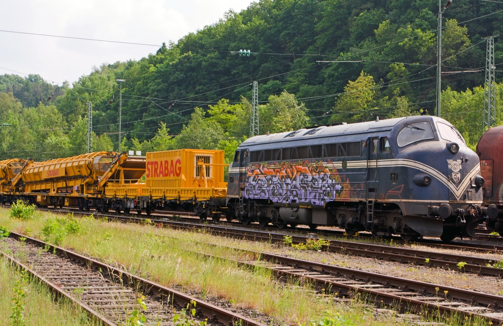 
Die 227 007-2, ex DSB MY 1147, dieser Typ ist in Deutschland auch bekannt als V 170 (eingestell als 92 80 1227 007-2 D-EIVEL) der STRABAG Rail GmbH, abgestell mit Bauzug (Materialförder- und Siloeinheit) am 30.05.2012 in Betzdorf/Sieg, leider bwaren hier Schmierfinken am Werk.  

Die Lok wurde 1964 für die DSB von Nydqvist och Holm AB (NoHAB) im schwedischen Trollhättan gebaut, ihr GM type 567C, 16 Zylinder, zweitakt-Motor hat eine Leistung von 1433 kW (1950 PS) bei 835 U/min, die Kraftübertragung erfolgt dieselelektrisch, die Höchstgeschwindigkeit 133 km/h. 

Die NOHAB AA16, auch „NOHAB“ oder umgangssprachlich „Kartoffelkäfer“ genannt, ist die europäische Lizenz-Variante der amerikanischen Standardlokomotiven der F-Reihe von EMD, seinerzeit einer Tochter des GM-Konzerns. Diese dieselelektrische Lok wurde von vielen Bahnverwaltungen in Ost- und Westeuropa in Varianten mit den Achsfolgen Co'Co' oder (A1A)(A1A) beschafft und ist noch heute im Einsatz. Benannt sind die NOHABs nach ihrem ersten europäischen Hersteller, Nydqvist och Holm AB im schwedischen Trollhättan. Dabei hat sich der Begriff „NOHAB“ für diese Loktype eingebürgert, obwohl das Unternehmen auch viele andere Loks gebaut hat, darunter etliche weitere Dieselloks mit EMD-Technik. Wer nach mehr über diese Loks wissen möchte hier drei Links: 
http://de.wikipedia.org/wiki/NoHAB_AA16 
http://www.sebtus.de/hist_v_170_story.html
http://nohab-gm.de/index.php