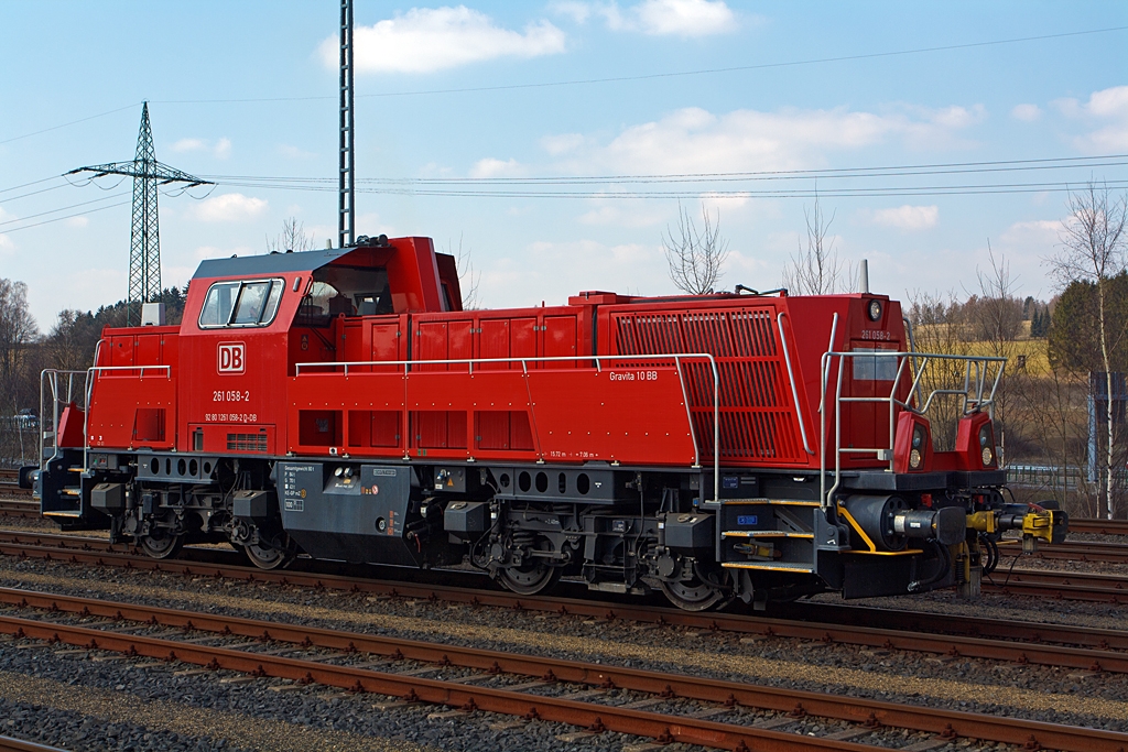 Die 261 058-2 eine Voith Gravita 10BB der DB Schenker Rail Deutschland AG am 07.04.2013 im Bahnhof Montabaur.

Die Lok wurde 2011 bei Voith unter der Fabriknummer L04-10109 gebaut. Die komplette NVR-Nummer ist 92 80 1261 058-2 D-DB.

Die Leistungs�bertragung erfolgt vom Motor �ber das Wandlergetriebe �ber Gelenkwellen (Kardanwellen) auf die einzelnen Achsgetriebe.

Technische Daten:
Achsfolge: B´B´
Spurweite: 1.435 mm  
L�nge �ber Puffer: 15.720mm
Motor: MTU 8V 4000 R43
Leistung: 1.000 KW / 1.360 PS  bei 1.800 Upm (gedrosselt)
Getriebe: Voith, Typ L 4r4 zseU2
H�chstgeschwindigkeit: 100 km/h Streckengang, 50 km/h Rangiergang
Dienstgewicht: 80,0 t
Befahrbarer Bogenradius: R 80 m
