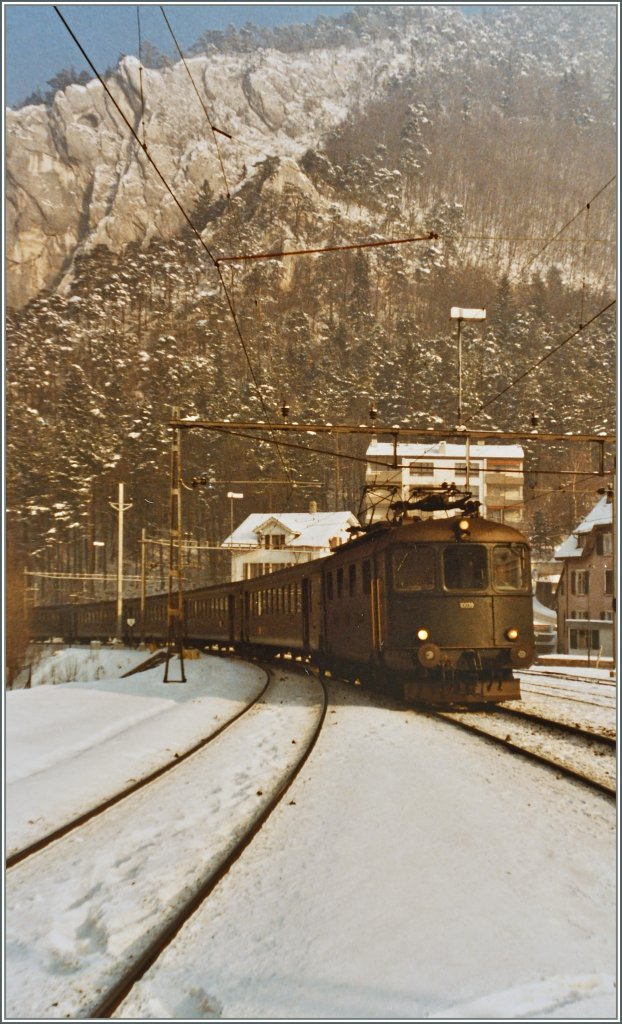 Die Re 4/4 I 10039 verl�sst mit ihrem Schnellzug die Klus von Moutier und erreicht den Bahnhof Moutier.
17. Jan. 1985