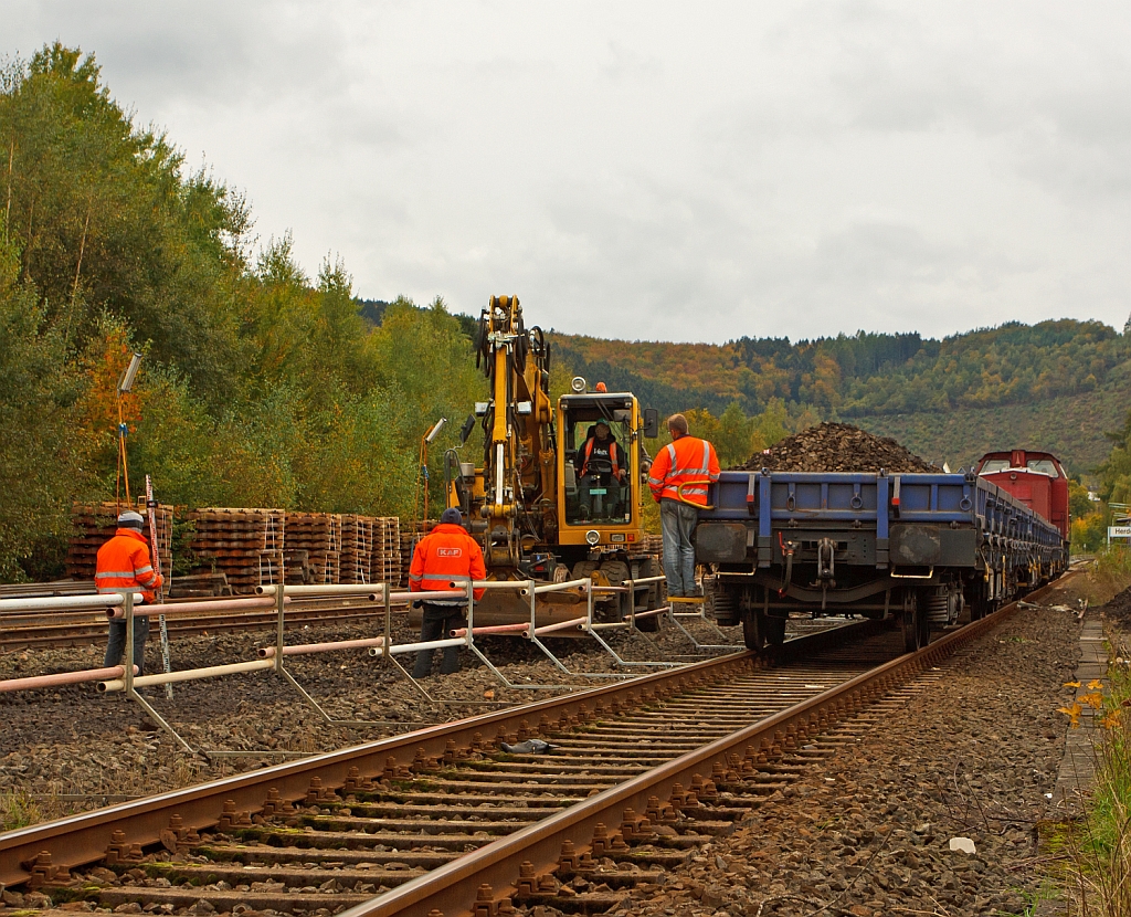 Gleisbaustelle Bf. Herdorf am 14.10.2012 (Erneuerung Gleis 2) - Die V 100.05 (202 726-6) der HGB (Hessische G�terbahn GmbH, Buseck) ex DR 110 726-7 ex DB 202 726-6 steht mit ihren 3 Res G�terwagen (Drehgestellflachwagen mit vier Rads�tzen) auf Gleis 1, im Gleis 2 ist ein Bagger der den Altschotter austr�gt und auf die G�terwagen ablegt.