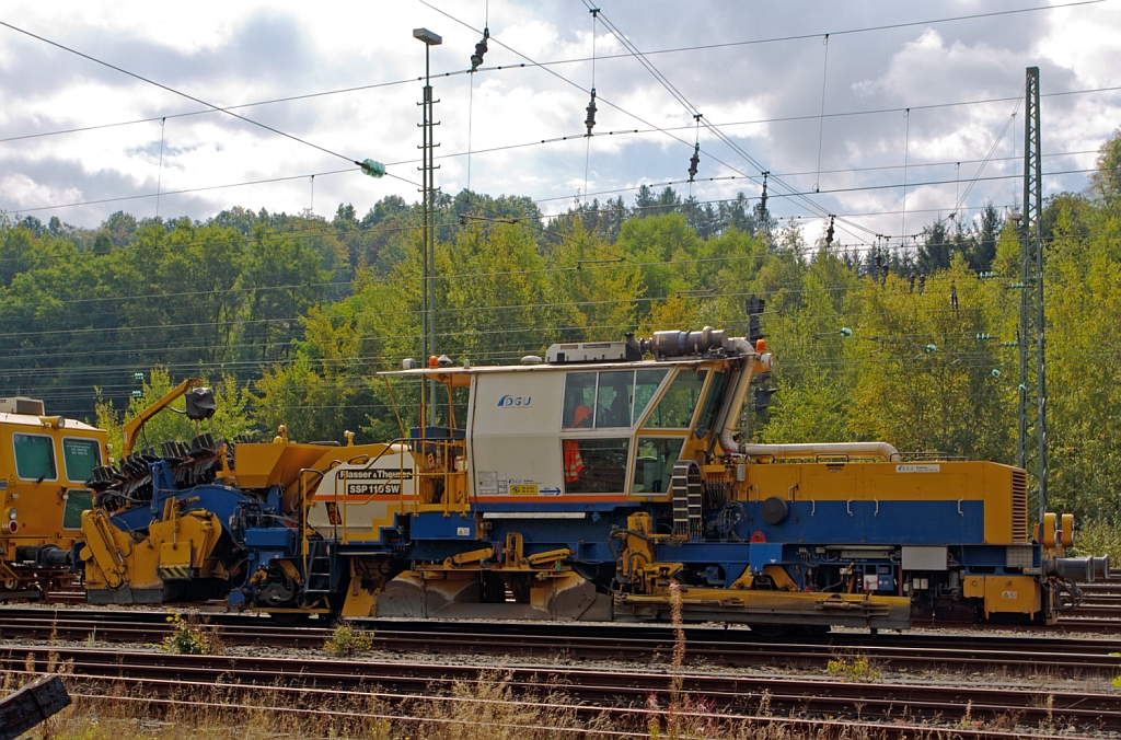 Plasser & Theurer Schnellschotterplaniermaschine SSP 110 SW  (Schweres Nebenfahrzeug Nr. 97 16 46 509 18-4) der DGU - Deutsche Gleisbau Union (Koblenz), abgestellt am 22.09.2012 in Betzdorf/Sieg. Techn. Daten:  Gesamtl�nge �ber Puffer 17.500 mm  >  Anzahl der Achsen 2  >  Gewicht 44.000 kg  >  Max. Eigenfahrgeschwindigkeit 100 km/h   >  Leistung 400 kW  (Deutz BF8M 1015C Motor)  >  Spurma� 1.435mm  >  zugelassen f�r Streckenklasse D4 oder h�her. 

Die Schotterverteil- und Planiermaschinen SSP 110 SW stellen den erforderlichen Regelbettungsquerschnitt in Gleisen und Weichen her. 
Die Maschinen verf�llen, planieren und kehren das Gleis.
Sie verf�gen �ber Besenwellen f�r alle Oberbauformen. Diese Maschine hat ein Steilf�rderer der �bersch�ssiger Schotter in das Silo f�rdert,  woraus der Schotter bei Bedarf dem Gleis dosiert wieder zugef�hrt wird.