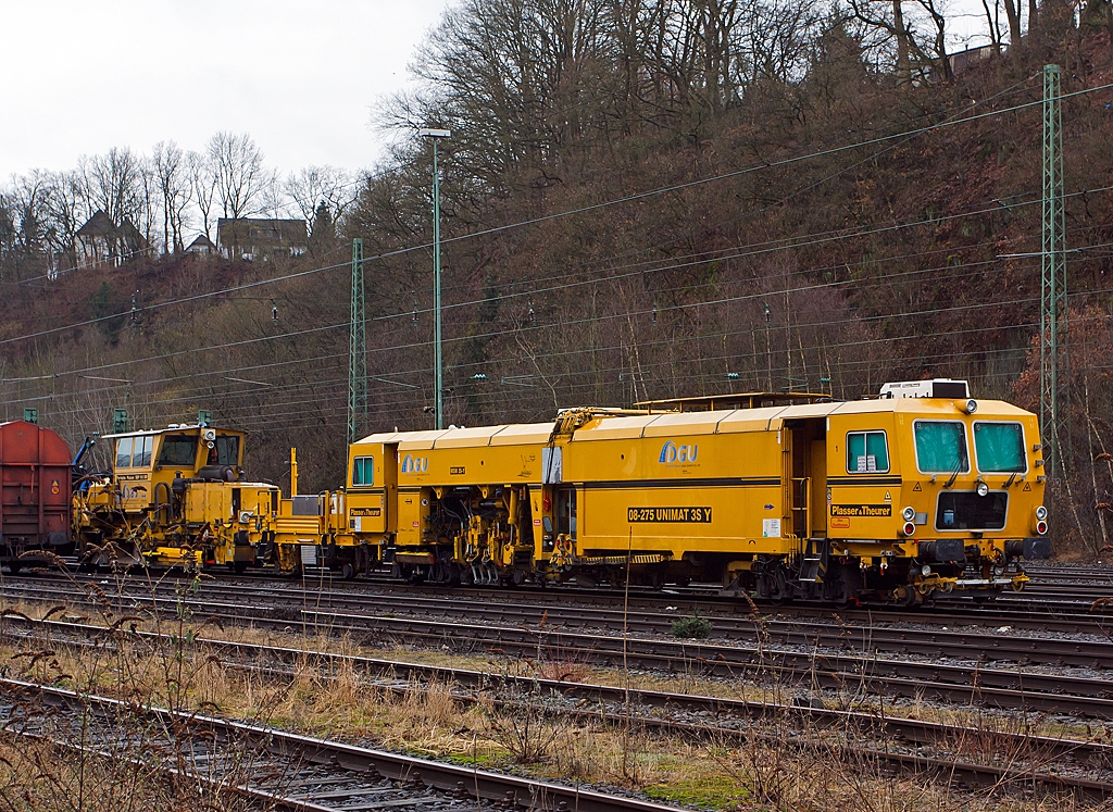 Plasser & Theurer Universalstopfmaschine 08 - 275 Unimat 3S Y (Schweres Nebenfahrzeug Nr. 97 43 41 523 17 - 9) der DGU (Deutsche Gleisbau Union), abgestellt am 09.03.2013 in Betzdorf/Sieg.

Die Maschine ist eine halbautomatisch arbeitende Nivellier-, Hebe-, Richt- und Stopfmaschinen. Sie dient zum Stopfen von Weichen und Gleisen, sie bearbeitet auch Gleise mit Y-Schwellen. Sie wurde 2001 unter der Masch.-Nr. 1172 gebaut.
Technische Daten: 
Eigengewicht: 78 t
L�nge �ber Puffer: 28.000 mm
Achsanzahl: 5 
Motorleistung: 348 kW
Fahrgeschwindigkeit mit Eigenantrieb: 100 km/h
zul. Streckenklasse: B2 oder h�her
Arbeitsleistung bei Durcharbeitung im Gleis: 400 m/h
Arbeitsleistung bei Durcharbeitung von Weichen: bis zu 8 Weichen in 10 h

Dahinter eine Schotterverteil- und Planiermaschine SSP 110 SW.