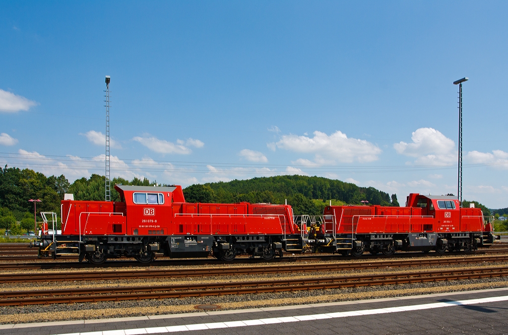 Zwei Voith Gravita 10 BB, die  261 079-8  und 261 054-1 der DB Schenker Rail abgestellt am 09.07.2013 beim Bahnhof Montabaur.
Die 261 054-1 wurde 2011 unter der L04-10105 gebaut und hat die kompl. NVR-Nummer 92 80 1261 054-1 D-DB. 
Die 261 079-8 wurde 2012 unter der L04-10130 gebaut und hat die kompl. NVR-Nummer 92 80 1261 079-8 D-DB, sowie die  EBA 08K03K 079.

Technische Daten:
Spurweite: 1.435 mm
Bauart: B'B'-dh
L�nge �ber Puffer: 15.720 mm 
Radsatzstand: 2.400 mm
Drehgestellmittenabstand: 7.060 mm
gr��te Breite: 3.025 mm
kleinster bef. Gleisbogen: 80 m 80 m 80 m
Dienstgewicht: 80t
Kraftstoffvorrat: 3.300 l  
H�chstgeschwindigkeit: 100 km/h Streckengang / 50 km/h Rangiergang 
kleinste Dauergeschwindigkeit: 6 km/h

Baujahr: seit 2008

Motorhauptdaten:
Motorbauart: MTU 8-Zylinder-Diesel-V-Motor 90� mit Common-
Rail-Einspritzsystem, Turbolader und Ladeluftk�hlung
Motortyp:   8V 4000 R43 (gilt f�r alle der DB BR 261, andere 8V 4000 R41)
Nennleistung:  1000 kW / 1341 PS (gedrosselt)
Drehzahl max.:  1800  1/min   
Bohrung/Hub: 170/210 mm
Hubraum: 38,2 l
Kraftstoffverbrauch bei Nennleistung: 248,2 l/h
Abgas-Emission :   EU Nonroad Richtlinie 97/68 EG, Stufe IIIA konform / UIC Kodex 624V, Stufe III 
L�nge: 2.000 mm
Breite: 1.565 mm
H�he: 2.015 mm
Gewicht (trocken): 5.250 kg

Getriebe und Leistungs�bertragung:
Hydrodynamisches-Voith-Getriebe vom Typ L 4r4 zseU2
Die Typenbezeichnung bedeutet: L = Lok, 4 = Gr��e, r = Reversierbarkeit, 4 = vier Wandler, z = verst�rkte Ausf�hrung, s = mechanisches Stufengetriebe, e = elektronische Steuerung, U2 = Abtriebsbauart.
Das Vierwandler-Turbowendegetriebe ist �ber eine hochelastische Kupplung mit der Abtriebsseite des Dieselmotors verbunden, um die �bertragung von Schwingungen zu vermindern. Es ist ein nach dem Erfinder benannte K�sel-Kupplung.
Das Getriebe hat f�r jede Fahrtrichtung zwei Wandler, also je einen Anfahrwandler und einen Marschwandler, die je nach Betriebssituation gef�llt oder geleert werden.
Eine Zugkraftunterbrechung beim Umschalten von einem Wandler zum anderen erfolgt nicht. Ein Schaltgetriebe zum Wechsel der Fahrtrichtung ist durch diese Funktionsweise nicht vorhanden. Vorteil dieser L�sung ist ein schneller Richtungswechsel ohne mechanischen Schaltvorgang, was gerade bei Rangierlokomotiven mit h�ufigen Fahrtrichtungswechseln von Nutzen ist. Das Getriebe ist in der Lage, die Lok hydrodynamisch abzubremsen, wobei je nach Fahrtrichtung der Wandler f�r die Gegenrichtung gef�llt wird.

Die Leistungs�bertragung auf die Achsgetriebe erfolgt dann �ber Gelenkwellen.
