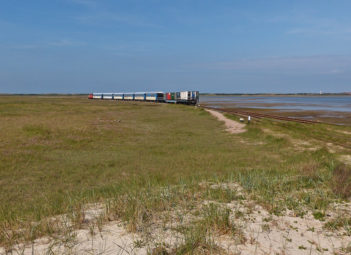 . Auf dem Weg zur F�hre am Westanleger in Wangerooge gelang mir noch dieser Nachschuss auf den Zug der Wangerooger Inselbahn, welcher �ber den steinernen Damm durch die Salzwiesen in Richtung Bahnhof im Inseldorf unterwegs ist. 07.05.2012 (Hans)