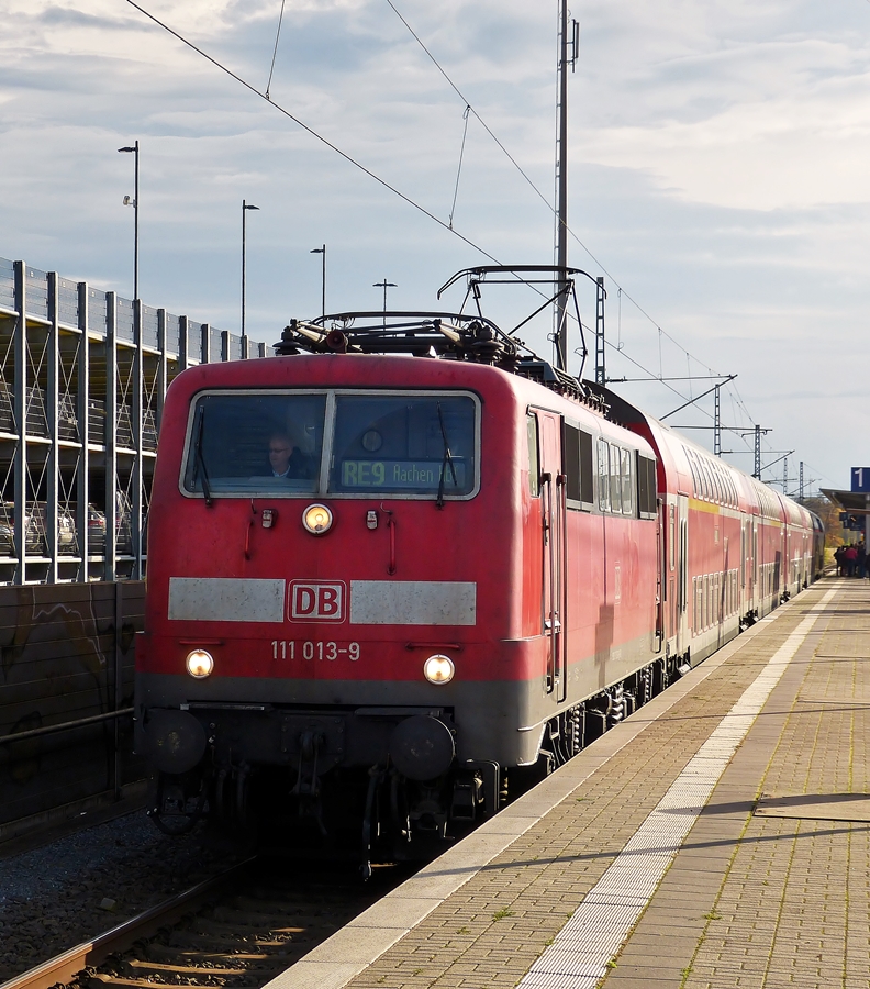 . Auf der Heimfahrt hatten wir mehr Gl�ck, der RE 9 (Rhein-Sieg-Express) Siegen Hbf - Aachen Hbf bestand aus der E-Lok 111 013-9 und Dostos, sodass die Reise viel bequemer verlief, als die Hinfahrt im �berf�llten Hamster. Der Zug konnte nur im Gegenlicht in Troisdorf fotografiert werden, da wir in Betzdorf noch das Quer-durch's-Land Ticket am Automaten ziehen mussten. 03.11.2014 (Hans)