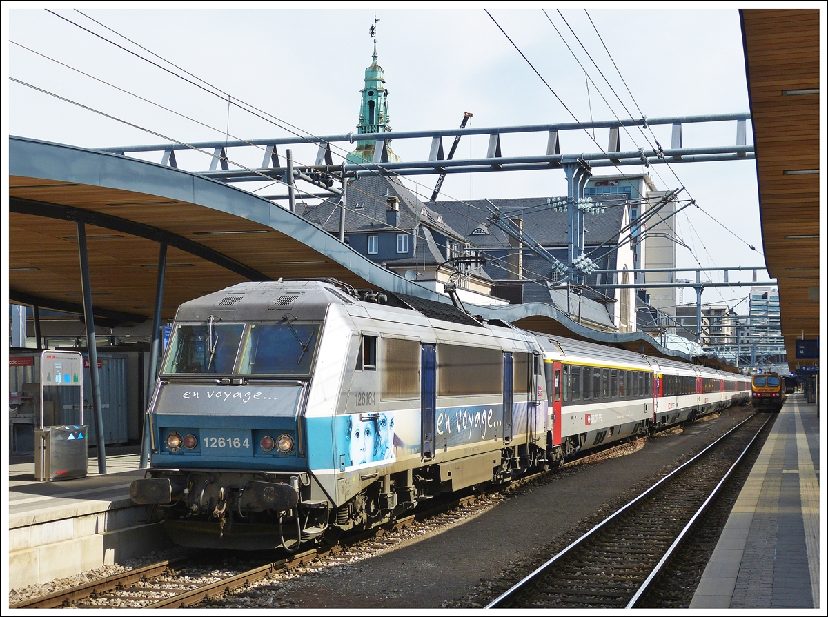 . Aus und vorbei - Bestimmt noch lange vor der Abschiedsfahrt f�r den Pinocchio, steht uns wieder ein Abschied ins Haus. Wie wir es schon lange bef�rchtet haben, werden die beiden  Prestige  Z�ge EC 90/91  Vauban  und EC 96/97  Iris  ab dem Fahrpalnwechsel am 15. Dezember 2013 nur noch nach/von Basel verkehren. Da sie dann nicht mehr in der Schweiz fahren, werden auch die SBB Wagen aus der Zuggarnitur verschwinden. Die SBB Wagen werden durch die SNCB Oldtimer I 6 (nicht klimatisiert) und SNCB I 10 (immerhin klimatisiert) ersetzt. Welch ein Qualit�tsverlust f�r diese Verbindungen.

Wir m�chten gar nicht wissen, was zum Fahrplanwechsel 2014 f�r diese Z�ge beschlossen wird. Man k�nnte es auch anders ausdr�cken: Der langsame aber sichere Tod von Vauban und Iris.

Zum Bild: Die SNCF BB 26164 hat am 17.06.2013 den EC 91  Vauban  in Luxemburg Stadt �bernommen, um diesen kurze Zeit sp�ter nach Basel zu ziehen. (Hans)

 