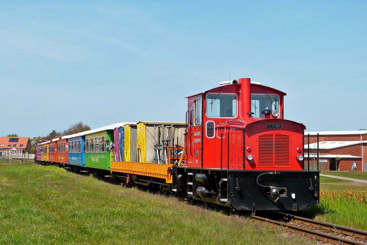 . Bei Kaiserwetter f�hrt ein Zug der Inselbahn Langeoog vom F�hranleger in Richtung Inselbahnhof. Am Ende des Zuges befindet sich die Lok 1, eine Sch�ma aus dem Jahr 1994. 05.05.2016 (Hans)

Die Inselbahn Langeoog ist eine nicht elektrifizierte, meterspurige und eingleisige Schmalspurbahn auf der ostfriesischen Insel Langeoog. Sie wird vom Eigenbetrieb Schiffahrt der Inselgemeinde Langeoog betrieben. Die Inselbahn verbindet auf 2,6 Kilometer L�nge den F�hrhafen mit dem Ort Langeoog. Die Fahrzeit f�r die Strecke betr�gt etwa sieben Minuten. Die Inselbahn Langeoog ist neben der Museumspferdebahn Spiekeroog die k�rzeste der deutschen Inselbahnen und f�hrt seit April 2008 nur noch Personenverkehr durch.

Seit 1995 verkehren im Regelpersonenverkehr zwei Sandwich-Wendezug-Garnituren, die beide seit 2005 �ber zwei Wagen mit Einstiegshilfen f�r Rollst�hle (die Freifahrt ist auf F�hre und Bahn gegeben) und Kinderwagen verf�gen. Diese fahren meist in der Mitte und am n�rdlichen Zugende; die Reihenfolge der �brigen Wagen und damit auch das farbliche Erscheinungsbild der Z�ge variiert bisweilen.
