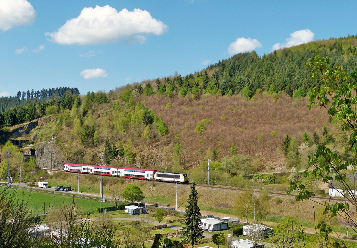 . Bereits um 11.06 Uhr tummelten sich die ersten Wolken am immer noch blauen Himmel, als der IR 3710 Luxembourg - Troisvierges, gezogen von der 3003, den Tunnel Scheidem�hle verliess und den Camping Platz von Clervaux erreichte. 21.04.2014 (Jeanny)