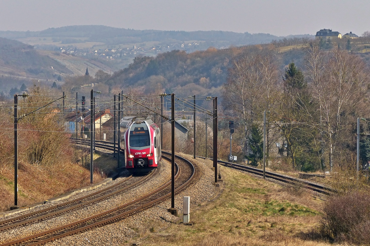 . Der CFL KISS Z 2305 hat vor kurzem als RE 5208 Trier Hbf - Luxembourg den Bahnhof von Wasserbillig verlassen und damit auch das leicht nebelige Moseltal hinter scih gelassen. In Mertert hat der Zug schon ganz sch�n an H�he gewonnen auf der 37,4 km langen Linie 30. Der H�henunterschied zwischen Wasserbillig und Luxemburg-Stadt betr�gt 170 H�henmeter und die maximale Steigung der Strecke betr�gt 15 ‰. Unter verl�uft die Anschlussstrecke zum Moselhafen in Mertert. 18.05.2015 (Jeanny) 