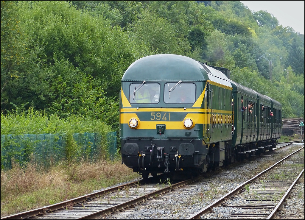 . Die tolle HLD 5941 mit dem coolen Sound erreicht mit ihrem Sonderzug den Bahnhof Dorinne-Durnal. 17.08.2013 (Hans)

Nach dem Zweiten Weltkrieg erhielten die NMBS/SNCB zun�chst ausw�rtige Dampflokomotiven zur Wiederaufnahme des Eisenbahnbetriebs im Lande, so die Reihe 29 aus Kanada und die Reihen 25 und 26 aus Teilen deutscher Kriegslokomotiven. Es zeigte sich jedoch bald, dass die Anschaffung von Diesellokomotiven auf Dauer rentabler war.

Urspr�nglich war eine Einheitsserie von schweren sechsachsigen Lokomotiven vorgesehen, die landesweit zum Einsatz kommen sollten. Die NMBS/SNCB entschied sich jedoch f�r eine weitere Lokomotivgattung speziell f�r den Einsatz vor schweren Z�gen im Flachland, so dass die Reihe 201 (59) parallel zu den f�r die Ardennenstrecken vorgesehenen Reihen 202, 203 und 204 (52, 53, 54) entstand. Anders als bei diesen erfolgte die Motorkonstruktion nicht durch den US-amerikanischen Hersteller General Motors, sondern durch die belgischen Lieferanten Cockerill, Baume & Marpent und Nivelles. Die elektrische Ausr�stung lieferte ACEC.

Die Kopfenden hatten urspr�nglich nur je zwei Signale; �ber einen Farbfilter wurde zwischen Spitzen- und Schlusssignal gewechselt. Ab 1971 erhielten die Lokomotiven dann die �blichen Dreilicht-Spitzensignale sowie getrennte Zugschlusssignale.

Die Fahrzeuge verkehrten sowohl im Personen- als auch im G�terzugverkehr. Mit Einf�hrung des Intercity- und Interregio-Verkehrs ab 1984 wurden die Loks auf dem Personenverkehr entfernt. Mit der fortschreitenden Elektrifizierung erfolgte ab 1987 die vollst�ndige Ausmusterung. Einige Exemplare wurden nach ihrer Abstellung vor�bergehend von der SNCF geliehen zum Bau der LGV Nord eingesetzt. Im Februar 1993 kehrten sie zur NMBS/SNCB zur�ck und versahen dort bis 2002 ihren Dienst beim Bau der HSL 1 und HSL 2.

Zum Schluss noch die technischen Daten der S�rie 59:

Nummerierung: 201.001–201.055 (5901–5903, 5905–5933, 5935–5955)
Anzahl: 55 
Hersteller: Cockerill, ACEC 
Baujahr(e): 1954–1955 
Ausmusterung: 2002 
Achsformel: Bo'Bo' 
Spurweite: 1435 mm (Normalspur) 
L�nge �ber Puffer: 16.180 mm 
H�he: 4.120 mm 
Breite: 2.875 mm 
Drehzapfenabstand: 7.840 mm 
Drehgestellachsstand: 2.680 mm 
Dienstmasse: 87,2 t 
H�chstgeschwindigkeit: 120 km/h 
Installierte Leistung: 1.280 kW 
Anfahrzugkraft: 196 kN 
Treibraddurchmesser: 1.018 mm 
Motorentyp: Cockerill 608A 
Nenndrehzahl: 625/min 
Leistungs�bertragung: elektrisch 
Kupplungstyp: Schraubenkupplung



