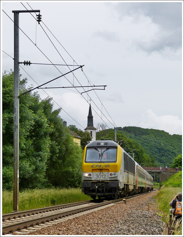. Die Vorteile des alten Zauns in Michelau - Vielbeachtet f�hrt am 15.06.2013 die 3012 mit dem IR 116 Luxembourg - Liers am Haken durch die Ortschaft Michelau. Der alte Zaun bot den Fotografen viele M�glichkeiten zur Bildgestaltung an dieser Stelle, welche durch das Anbringen der neuen Abgrenzung nun verbaut sind. (Hans)