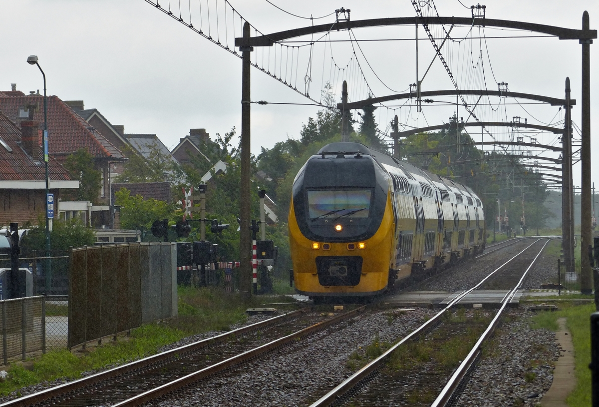 . Im st�rmenden Regen braust ein sechsteiliger NS VIRM (Verlengd interregiomaterieel) unter den sch�nen alten Fahrleitungsmasten ohne Halt durch den Bahnhof von Zevenbergen. Er f�hrt als IC Lelystad - Amsterdam Centraal - Roosendaal - Vlissingen auf der Bahnstrecke N� 12 Antwerpen - Lage Zwaluwe in der niederl�ndischen Provinz Noord-Brabant. 04.09.2015 (Jeanny)