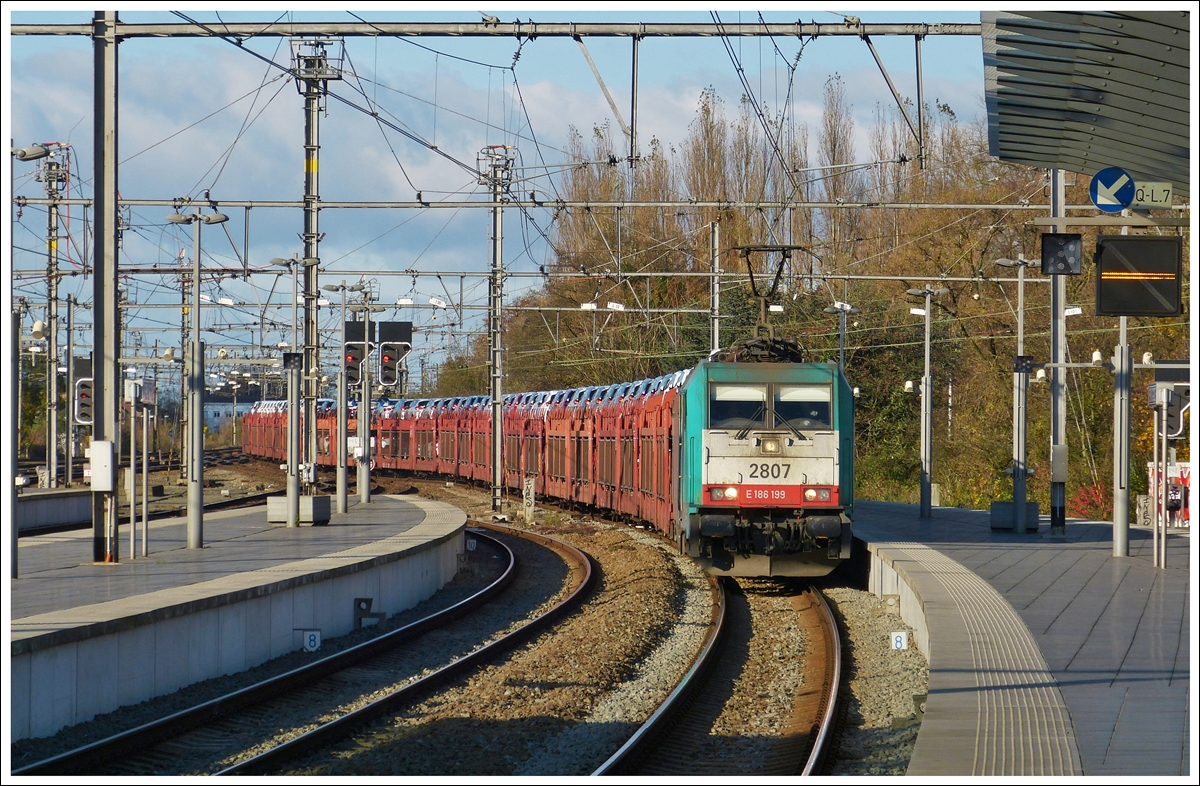 . Leider keine Class 66, sondern  nur  eine Traxx habe ich fotografiert. Am 23.11.2013 zieht die Traxx HLE 2807 einen langen Autozug durch den sch�nen Bahnhof von Br�gge (Bruges/Brugge). (Hans)