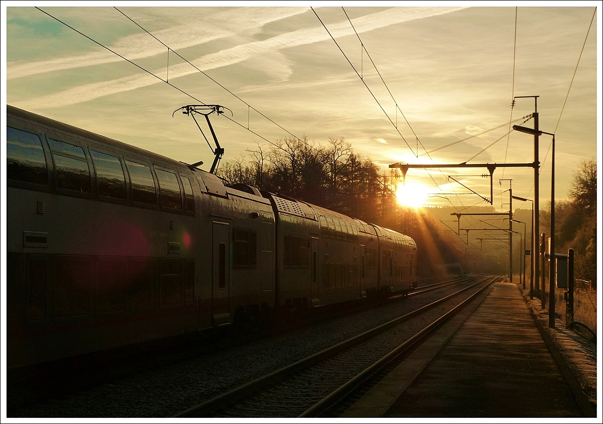 . P�nktlich zum Sonnenaufgang am 16.12.2013 erreicht der IR 3708 Luxembourg - Troisvierges den Bahnhof von Wilwerwiltz. (Jeanny)