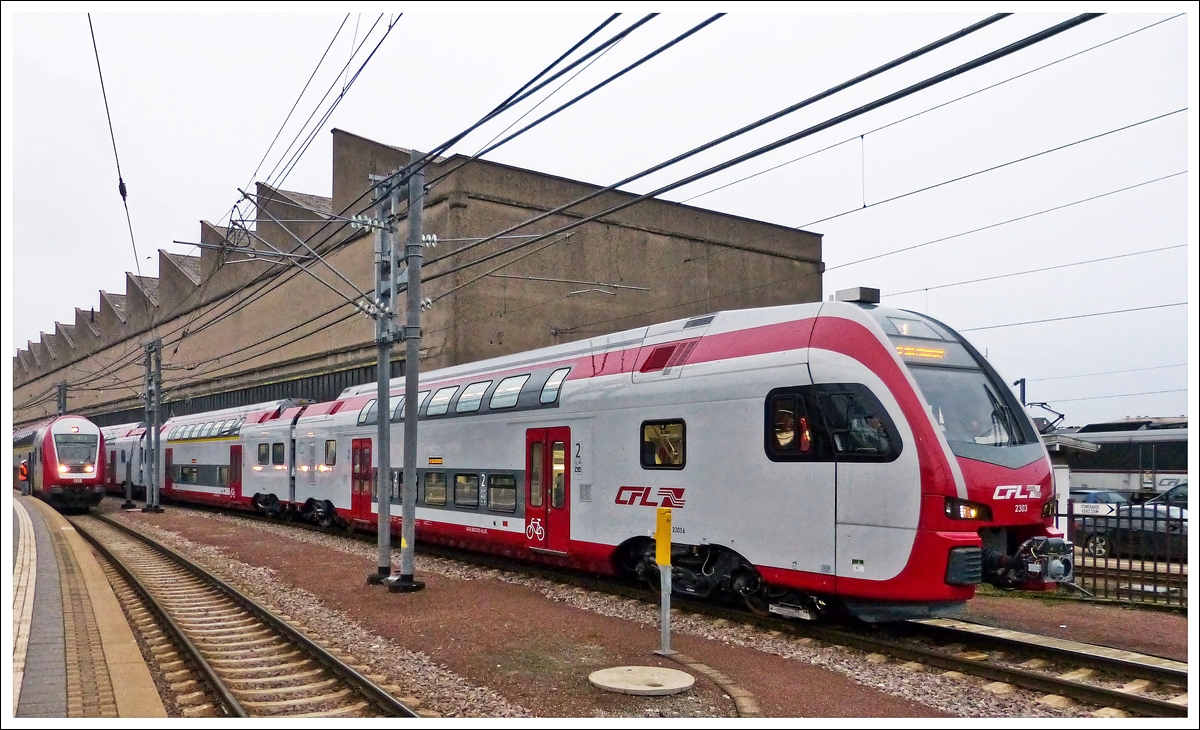 . �berraschung im Bahnhof von Luxemburg - Am tr�ben 22.01.2014 fuhr mir der CFL Kiss 2303 w�hrend einer Testfahrt im Bahnhof von Luxemburg vor die Linse. (Hans)

Die „Soci�t� Nationale des Chemins de Fer Luxembourgeois“ (CFL) hat f�r den Betrieb in Luxemburg und den grenz�berschreitenden Verkehr nach Deutschland acht dreiteilige Doppelstocktriebz�ge bei der Firma Stadler (Schweiz) bestellt. Das Auftragsvolumen liegt bei ca. 60 Mio. Euro.

Die 80 Meter langen Fahrzeuge verf�gen �ber eine Kapazit�t von 300 Sitzpl�tzen. Kundenfreundlich gestaltete Sitzabst�nde f�r alle Fahrg�ste und ein sehr komfortabler 1. Klasse-Bereich zeichnen den Innenraum aus. Zudem ist Platz f�r 24 Fahrr�der sowie drei Rollst�hle. Die elektrischen Doppelstock-Triebz�ge werden mit den zwei unterschiedlichen Spannungs- und Zugsicherungssystemen ausgestattet, um den Betrieb in Luxemburg und in Deutschland zu gew�hrleisten. F�r den Einsatz in Luxemburg ist die moderne europ�ische Zugsicherungstechnik ETCS bereits integriert. Die Fahrzeuge k�nnen eine maximale Geschwindigkeit von 160 km/h erreichen. Die CFL-Kapazit�ten werden durch den Ankauf um 2.400 Sitzpl�tze erh�ht.


Im Auftrag des Luxemburger Nachhaltigkeitsministeriums und des rheinland-pf�lzischen „Zweckverband Schienenpersonennahverkehr Nord“ sollen die 8 CFL - Doppelstocktriebz�ge Kiss ab 2014 auf der Strecke Luxemburg - Koblenz verkehren und im Stundentakt die Anbindung an den Fernverkehr herstellen.
