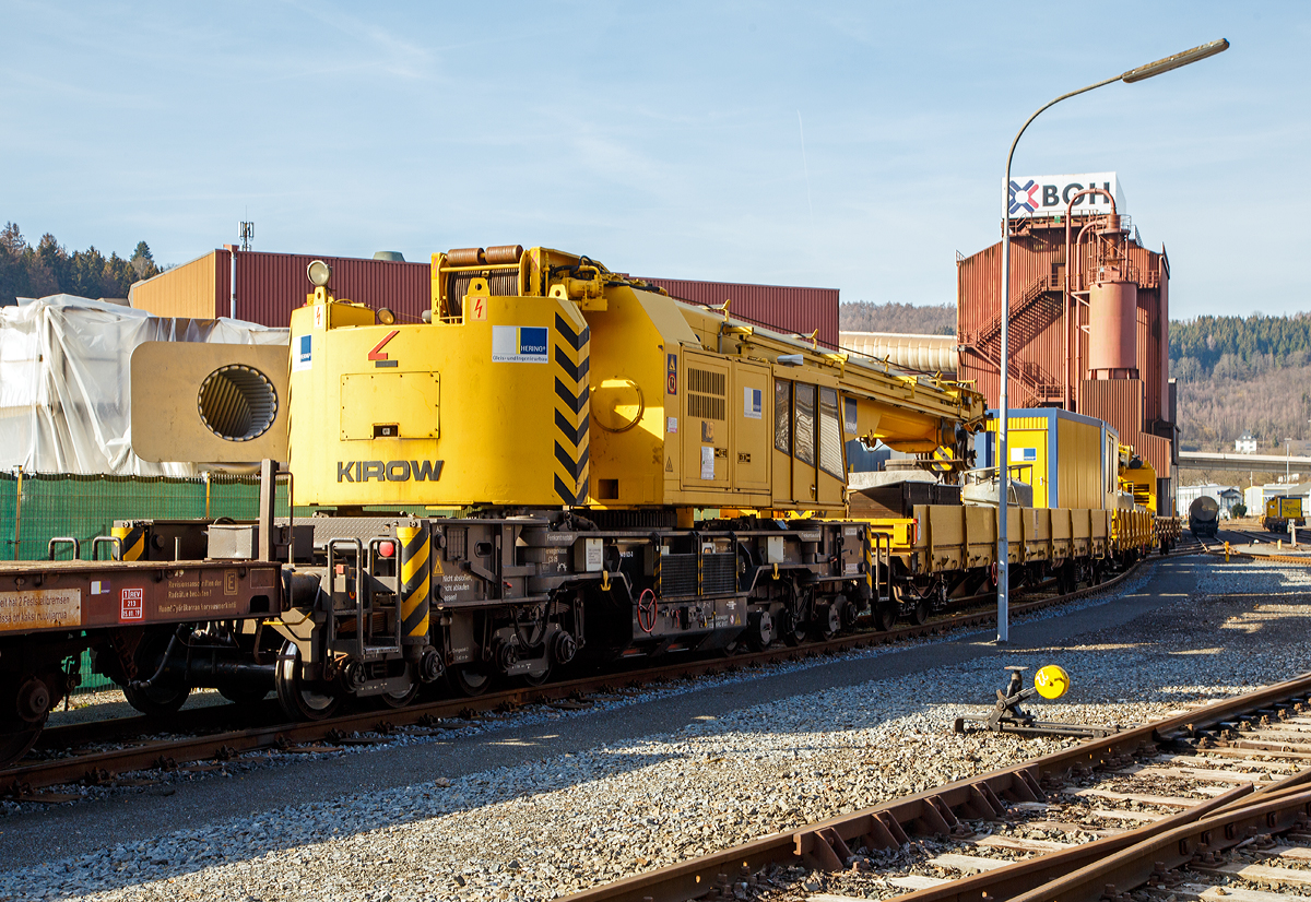 
125t - KIROW Gleisbauschienenkran KRC 810 T „BALU“ der Hering Bau (Burbach), Schweres Nebenfahrzeug Nr. D-HGUI 99 80 9419 023-3, ex 97 82 53 508 19-3, ex 60 80 092 3 931-3, abgestellt am 17.02.2019 in Siegen-Eintracht auf dem Gelände der KSW Kreisbahn Siegen-Wittgenstein GmbH.

Der Kran wurde 1999 von KIROW in Leipzig unter der Fabriknummer 112300 gebaut und an die Hering Bau geliefert. Die Firma Hering Bau gehört in Deutschland zu den größten Eisenbahnkran-Dienstleistern, sie hat 12 eigene Krane.

Der 125-t-Eisenbahndrehkran wird für den Aus-und Einbau von schweren Betonweichen, Gleisjochen und Hilfsbrücken sowie für die Montage von Ingenieurbauwerken eingesetzt. Bei Havarien auf Bahnstrecken leistet er schnelle Hilfe zum Bergen schwerer Lasten.

Technische Daten
Eigengewicht: 128 t
Länge über Puffer: 13.000 mm
Achsanzahl: 8
Drehzapfenabstand: 8.000 mm
Drehzapfenabstand im Drehgestell 1 und 2: 2.300 mm
Achsabstand in den Einzeldrehgestellen: 1.100mm
Ergebene Achsabstände in m: 1,1 / 1,2 / 1,1/ 4,6 / 1,1 / 1,2 / 1,1
Achsfolge: 1'A'1A'A1'A1'
Achslast: 16,0 t
Motorleistung: 235 kW
Fahrgeschwindigkeit im Zugverband: 120 km/h
Fahrgeschwindigkeit mit Eigenantrieb: 20 km/h
zul. Anhängelast: 80 t
Zugelassen als Schwerwagen für Streckenklasse: CS 05
kleinster befahrbarer Radius: 90 m

Tragfähigkeiten:
bei 0,00 m Ausladung vor Puffer, mit Schwerlastausrüstung: 125 t
bei 2,80 m Ausladung vor Puffer, ± 30°, abgestützt: 90 t
bei 2,80 m Ausladung vor Puffer, ± 20°, freistehend: 46 t
