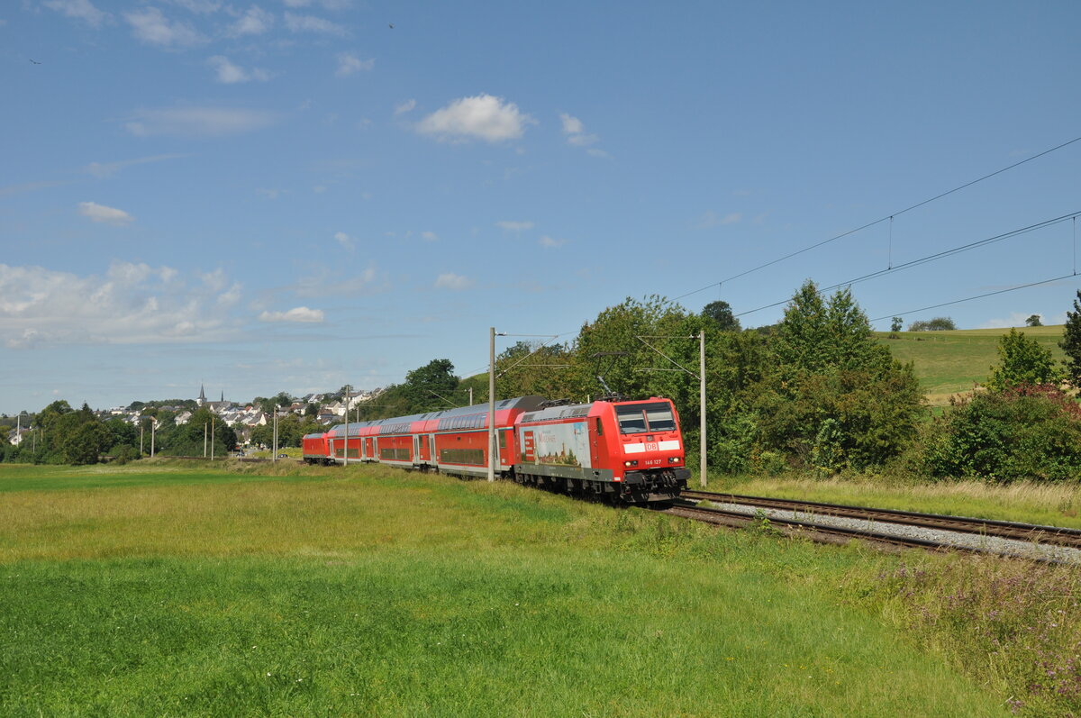 146 127 mit Werbung für den Erholungsort  Marienhafe  und 146 125 (am Zugende) sind am 14.08.2021 mit einer RB22 auf dem Weg nach Frankfurt Hbf und wurden dabei zwischen Niederbrechen und Oberbrechen fotografiert. 
Mittlerweile wurde 146 127 in Dessau modernisiert, ihre Werbung hat sie dabei leider verloren.