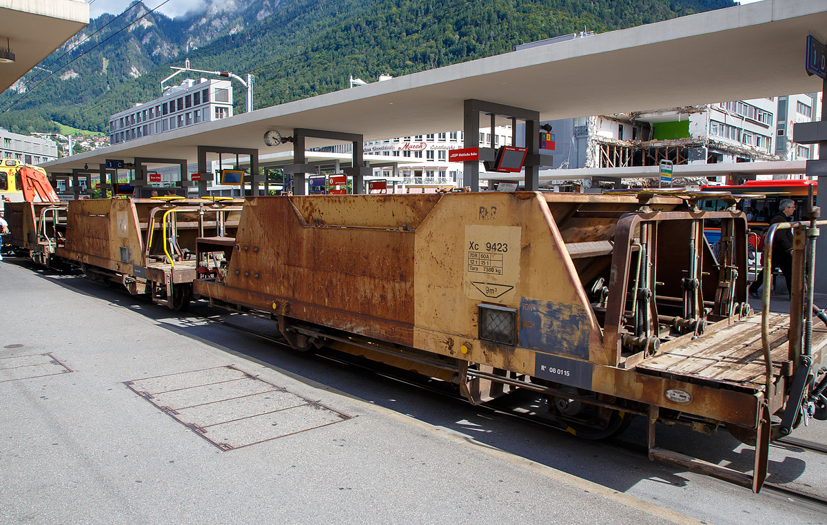 2-achsiger Talbot Schotterwagen mit 1 offenen Plattform RhB Xc 9423, ex RhB Fd 8663, am 12.09.2017 am Bahnhofsvorplatz im Zugverband eingereiht in einem aus Arosa kommenden Bauzug.

Diese Schotterwagen wurden 1965 von der Waggonfabrik Talbot in Aachen bebaut. Im Jahr 2004 wurden sie neu nummeriert, Fd 863 wurde nun zum Xc 9423.
 
TECHNISCHE DATEN:
Spurweite: 1.000 mm
Anzahl der Achsen: 2
L�nge �ber Puffer: 7.990 mm
Achsabstand: 4.000 mm 
H�he: 2.000 mm
Laufraddurchmesser: 750 mm (neu)
Eigengewicht: 7.380 kg
Ladegewicht: max. 15 t (bis 60 km/h) / 12 t (bis 70 km/h)
Max. Ladelvolumen: 9,0 m�
zul�ssige Geschwindigkeit: 60 km/h / 70 km/h

Wagenbescheibung:
Diese Talbot Schotterwagen des Typs Fd werden zum Transport und zum anschlie�enden direkten einbringen des Neuschotter ins Gleisbett verwendet. Entwickelt und gebaut wurden die Wagen von der Waggonfarbrik Talbot in Aachen. Die Wagen verf�gen dank ihrer Bauart �ber einen sehr niedrigen Schwerpunkt. Der Wagen besteht aus einem Chassisrahmen, an dem unten die beiden Achsen mit Federn, die Bremsausr�stung und die Luftbeh�lter angebaut sind. Und darauf eine Mulde mit 9m� Fassungsverm�gen f�r den Schotter. Am einen Wagenende befindet sich die Arbeitsb�hne mit Handbremskurbel und den Dossierr�dern f�r die Entladung. Die Dossierr�der erm�glichen jede Kammer einzeln, mit genau der ben�tigten Menge zu entleeren, so l�sst sich der Schotter bereits beim Entladen in der richtigen Menge dosiert, an der richtigen Stelle verteilen. Beim Entladen wird der Wagen langsam �ber den neu zu schotternden Gleisabschnitt gezogen und durch die mehr oder weniger ge�ffnete Entladevorrichtung, die sich nur gerade 35 cm �ber Schienenoberkannte befindet, f�llt der Schotter genau ins Gleisbett. Linke, Mitte und rechte Seites k�nnen dabei separat dossiert werden und das Schotterbett erh�lt bereits die Grundform der charakteristischen Form mit den Erh�hungen an den R�ndern und flach im Bereich der Schwellen. Die definitive Form erh�lt das Gleisbett anschlie�end dann durch eine Schotterplaniermaschine.

Die Schotterwagen Fd eignen sich nicht nur f�r Neuschotterung, sondern auch einfach bei einer Nachschotterung werden sie eingesetzt. Bei einer Nachschotterung ist es nicht immer zwingend notwendig, das Gleis noch mit der Schotterplaniermaschine nach zu bearbeiten. Die Fd verf�gen �ber eine durchgehende automatische Vakuumbremse mit 2-Stufigem Lastwechsel. Der Bremszylinder arbeitet auf jedes Rad, dass jeweils mit je zwei Bremskl�tzen ausger�stet ist. Die mechanische Handbremse wirkt nur auf die Achse bei der Arbeitsb�hne. 
