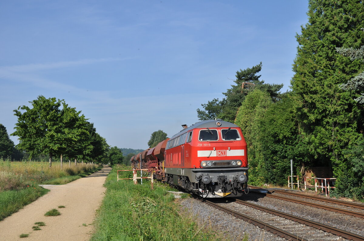 218 191-5 ist am 03.07.2021 mit einem Schotterzug auf dem Weg von Limburg(Lahn) nach Wallmerod und erreicht in Kürze Staffel. 