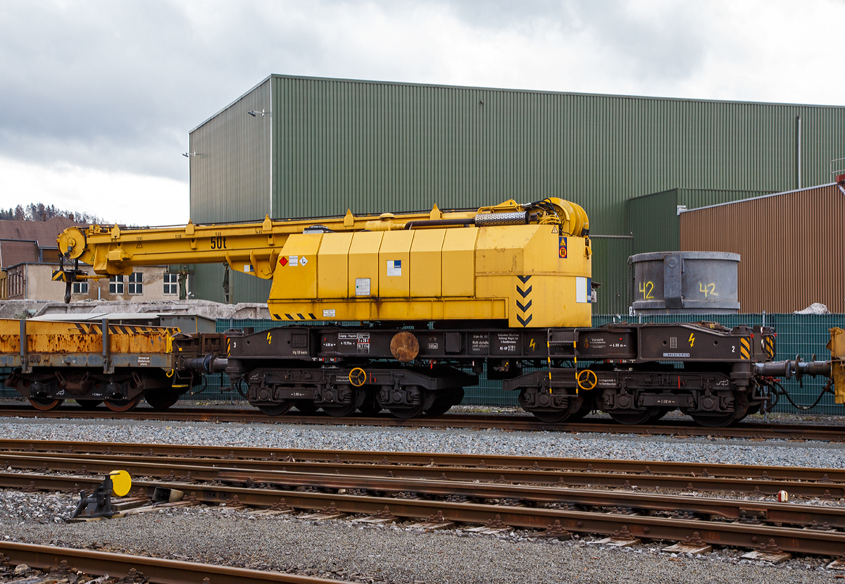 
50t-KIROW-Schienenkran TELVAR 50-1 der Hering Bau (Burbach),  Schweres Nebenfahrzeug Nr. 97 82 35 501 19-1,  mit dem Schutzwagen 80 80 3900 001-9 D-HGUI (Gattung Rs) und einem Res (mit unbek, Nr.), abgestellt am 09.03.2019 in Siegen-Eintracht auf dem Gel�nde der KSW Kreisbahn Siegen-Wittgenstein GmbH. 

Der Eisenbahndrehkran wurde 1992 von der Schwermaschinenbau KIROW Leipzig GmbH  (bis 1990 zum TAKRAF Kombinat) unter der Fabriknummer 1 gebaut. Er war wohl der erste gebaute Kran nach der Reprivatisierung 1990,  bis dahin bestand das TAKRAF Kombinat aus 26 Einzelbetrieben, zu denen auch der VEB Schwermaschinenbau S. M. Kirow Leipzig geh�rte.

TECHNISCHE DATEN:
Spurweite: 1.435 mm
Eigengewicht: 120 t
L�nge �ber Puffer: 13.600 mm
Achsanzahl: 6 (in zwei Drehgestellen)
Drehzapfenabstand: 6.000 mm
Achsabstand in den Einzeldrehgestellen: 3.000 mm (2x 1.500 mm)
Treib- und Laufraddurchmesser: 920 mm (neu)
Fahrgeschwindigkeit im Zugverband: 120 km/h
Fahrgeschwindigkeit mit Eigenantrieb: 20 km/h ohne Last 6 km/h mit Last
Zugelassen als Schwerwagen f�r Streckenklasse: CS04 und h�her
kleinster befahrbarer Radius: 80 m
Bremse: KE-GP

Tragf�higkeiten:
bei  8,00 m Ausladung vor Puffer:  50 t, freistehend: 46 t
bei 18,00 m Ausladung vor Puffer: 17 t, freistehend: 46 t
Hubgeschwindigkeit: bis 30 t 5,3m/min, bis 50 t 3,5 m/min