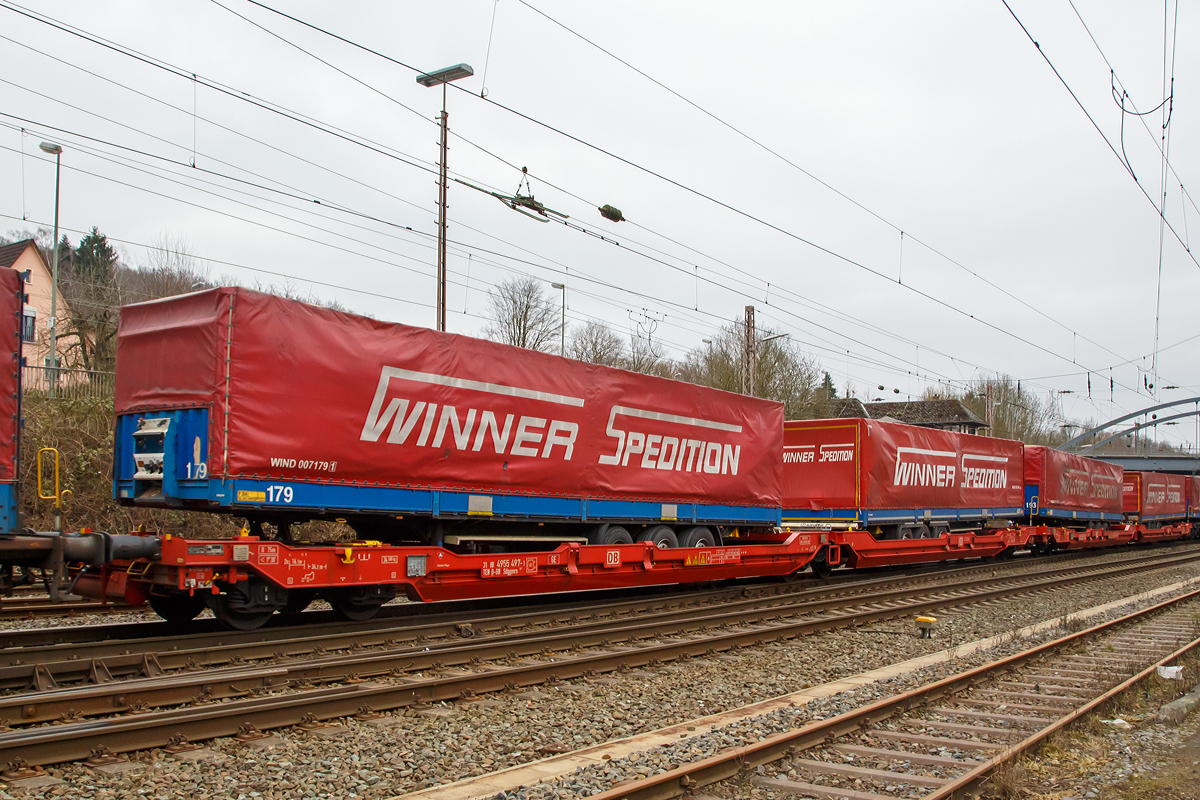 6-achsiger Gelenk-Taschenwagen 31 80 4955 497-1 TEN D-DB der Gattung Sdggmrs 738.1, der DB Schenker Rail Deutschland AG hier mit Stattelauflieger der Spedition Winner, am 12.03.2016 bei der Zugdurchfahrt in Kreuztal. 

Die Wagen werden nach einem Patent der Cattaneo SA (Schweiz) gebaut und sind baugleich zu Wagen von Kombiverkehr, Cemat, der CFL und Wascosa. M�gliche Ladeeinheiten sind, wie hier zwei Trailer oder alternativ bis zu vier Wechselbr�cken und/oder Container.

Technische Daten Sdggmrs 738.1:
Spurweite: 1.435 mm
Anzahl der Achsen: 6 (in drei Drehgestellen)
L�nge �ber Puffer:  34.200 mm
Drehzapfenabstand:  2 � 14.200 mm
Aufstandsh�he �ber SOK f�r Container:  1.155  mm
H�chstgeschwindigkeit: 120  km/h (leer und beladen)
Maximales Ladegewicht:  100,0  t
Eigengewicht:  34.580  kg
Drehgestell-Radsatzstand:  1.800  mm
Laufraddurchmesser: 920 mm (neu) / 840 mm (abgenutzt)
Kleinster bef. Gleisbogen:  R = 75  m
Bauart der Bremse:  2 � DK-GP-A
Handbremse:  Fbr1)