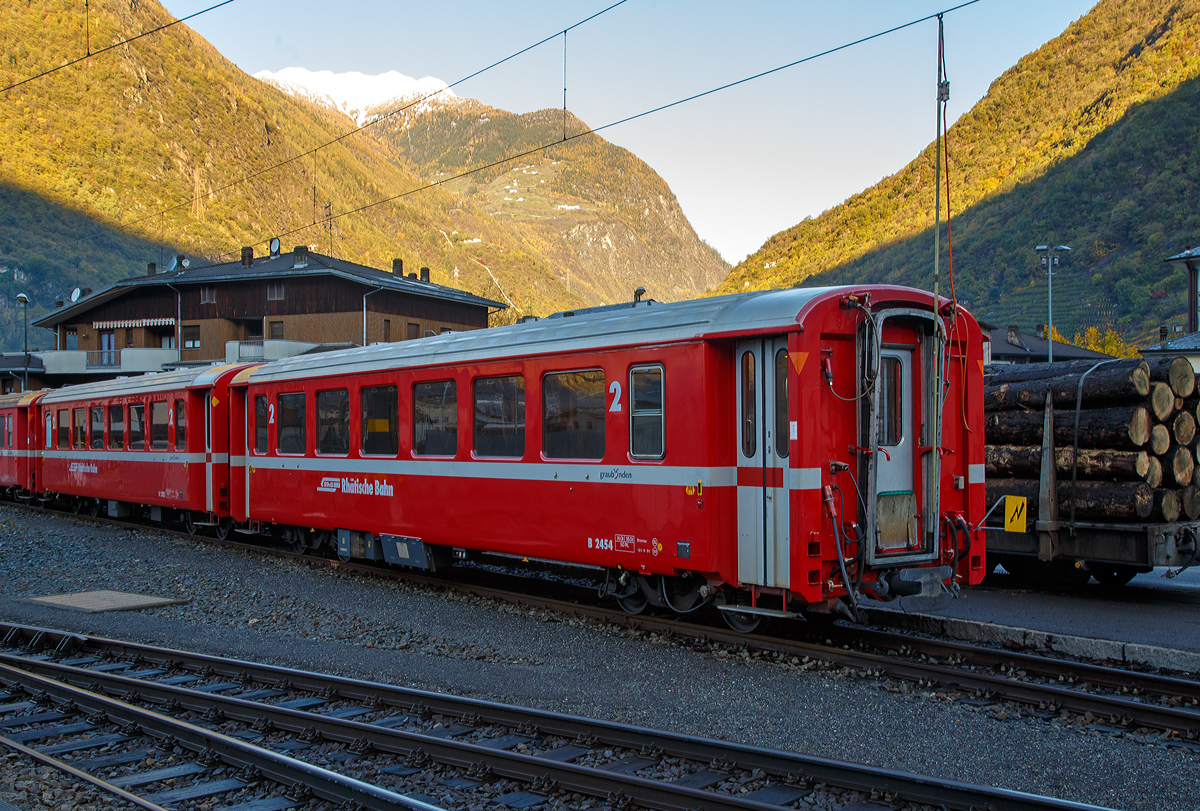 Am 04.11.2019 im RhB Bahnhof Tirano abgestellte (f�r die Berninabahn) verk�rzte RhB Einheitswagen I, elektrisch angeschlossen sind sie �ber eine Stromentnahme von der Oberleitung. Vorne der 2.Klasse Personenwagen RhB B 2454, dahinter der B 2312.

Mit mehr als 100 Fahrzeugen bilden die als Einheitswagen I bezeichneten Personenwagen bis heute die gr��te Serie im Rollmaterialbestand der RhB. Das Fahrzeugkonzept wurde Anfang der sechziger Jahre in enger Zusammenarbeit zwischen Industrie und RhB entwickelt. Als Neuheit galten damals die Einstiegsbereiche mit WC und Stauraum f�r sperriges Gep�ck an den Wagen�berg�ngen. Folglich weicht das Konzept deutlich von den Mitteleinstiegswagen aus den vierziger Jahren ab.

Die ersten von FFA und SIG gebauten Einheitswagen I wurden Ende 1963 in Betrieb genommen. In einem Zeitraum von etwa zehn Jahren wuchs der Bestand an EW I kontinuierlich. Neben den 18,42 m langen Wagen, die haupts�chlich auf dem Stammnetz eingesetzt werden, kamen auch Sonderbauformen mit Aluminiumwagenkasten hinzu. Zu diesen z�hlen auch diese auf 14,19 m verk�rzten Fahrzeuge f�r den Einsatz auf der Berninabahn.

TECHNISCHE DATEN (2.Klasse EW I, verk�rzt):
Hersteller Wagenkasten: FFA
Hersteller Drehgestelle:	 SWP
Inbetriebsetzung:	1968-72
Betriebsnummern:	B 2307-2314 und B 2451-2460
Anzahl Fahrzeuge:	18
Spurweite: 1.000 mm
L�nge �ber Kupplung:14.910 mm
Breite: 2.650 mm
Achsabstand im Drehgestell: 1.800 mm
Drehzapfenabstand: 9.240
Gewicht: 14.000 kg
Sitzpl�tze: 50
zul. H�chstgeschwindigkeit:	90 km/h
Lauff�hig: StN (Stammnetz) / BB (Berniabahn) / MGB (Matterhorn Gotthard Bahn)
