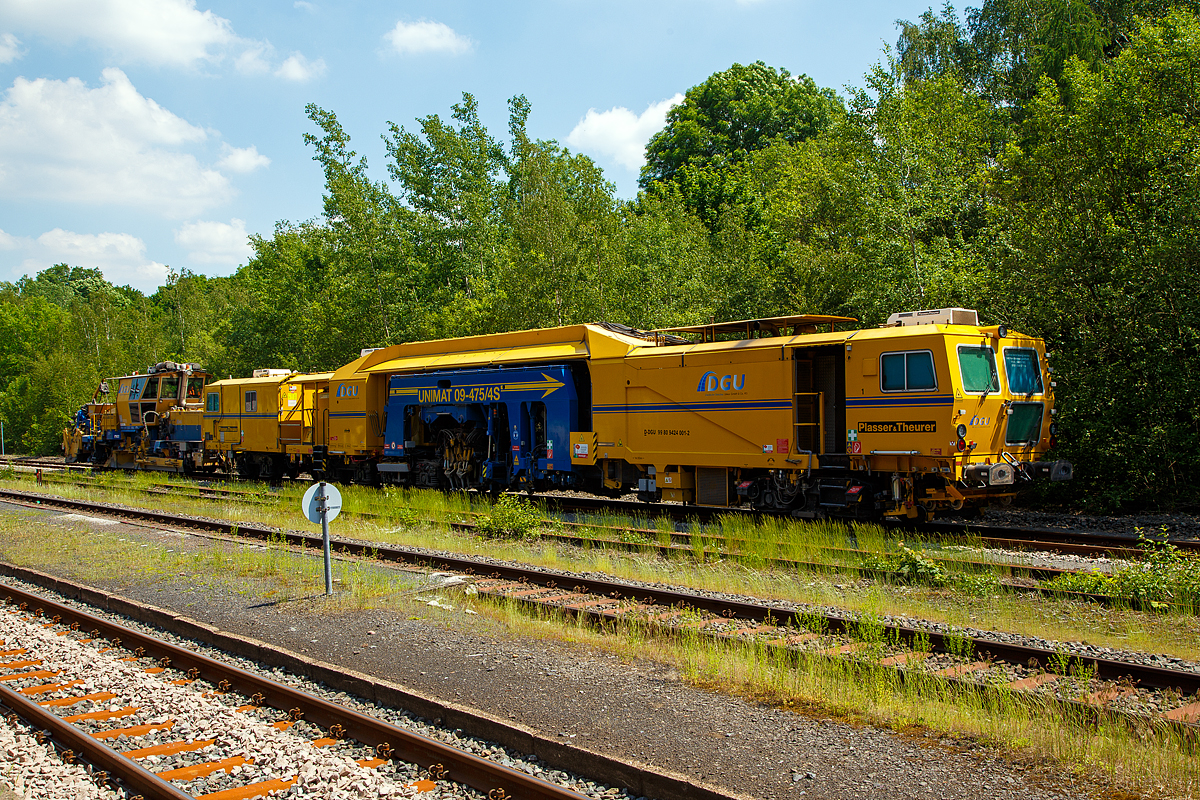 Am 11.06.2021 abgestellt auf dem Gleis 4 im Bahnhof Herdorf: Die Plasser & Theurer Universalstopfmaschine UNIMAT 09-475/4S (Kombinierte Gleis- und Weichenstopfmaschine), Schweres Nebenfahrzeug Nr. D-DGU 99 80 9424 001-2 und dahinter die Plasser & Theurer Schotterverteil- und Planiermaschine SSP 110 SW, Schweres Nebenfahrzeug Nr. D-DGU 99 80 9425 068-0, ex 97 16 46 516 18-9 D-DGU (ex Hering Gleisbau, ex Volker-Rail). Beide Maschinen gehören der der DGU - Deutsche Gleisbau Union aus Koblenz.