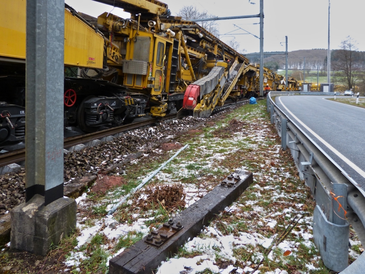 An einer Stra�enkurve neben der Bahnstrecke nahe Drauffelt, gelangen mir einige Bilder der Arbeitsweise des Gleisumbauzuges. Ein weiteres Transportband bef�rdert den alten Schotter  der vom Schild unter der Maschine an die Seiten gedr�ckt wurde zum Zentralf�rderband entsorgen des Schotters in die Siloeinheiten. 07.04.2021