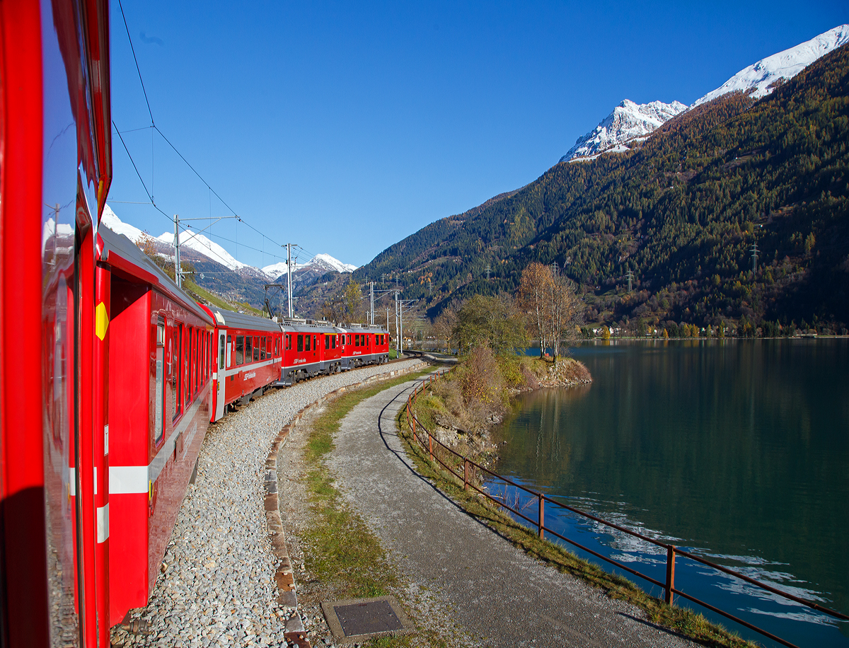 
Auf der Rückfahrt, bei und bestem Kaiserwetter....
Geführt von den beiden RhB ABe 4/4 III Triebwagen, Nr. 53  Tirano  und Nr. 54  Hakone , fährt unser RhB Regionalzug von Tirano nach St. Moritz, am Lago di Poschiavo entlang.