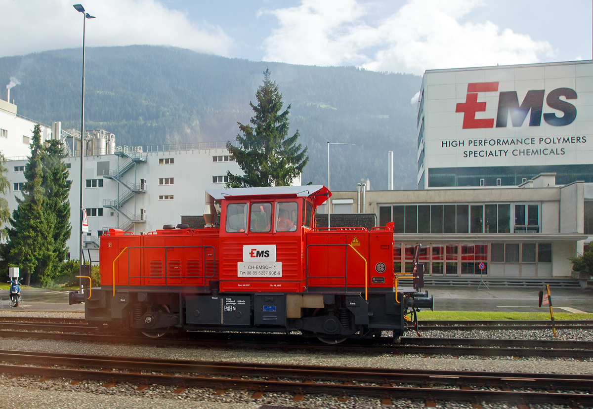 Aus dem Zug heraus, die Tm 237 932-9 (98 85 5237 932-9 CH-EMSCH) der EMS-Chemie AG rangiert am 12.09.2017 in Domat/Ems (Schweiz). 

Dabei handelt es sich um eine ehemalige zweiachsige tschechische ČKD Rangierlokomotive des Typs T 239 S01 aus dem Jahre 1994, die von ČKD Praha unter der Fabriknummer 16788 f�r die EMS Werke gebaut wurde. Von der LSB Lok Service Balmer AG in Hinwil wurde sie 2017 neu revidiert und remotorisiert.

TECHNISCHE DATEN:
Spurweite: 1.435 mm
Achsformel: B
L�nger �ber Puffer:  9.450 mm
H�he:  3.900 mm
Breite:  3.140 mm
Dienstgewicht:  44 t
Motor:  Deutz TCD2015V06 (V-6 –Zylinder-Dieselmotor)
Leistung:  490 PS 
H�chstgeschwindigkeit:  60 km/h (geschleppt 80 km/h)
Antrieb: dieselelektrisch  (mit 2 elektrischen Fraktionsmotoren)

Die Lokomotive der ČD Serie 709 (urspr�nglich als ČSD T 239.1 bezeichnet) ist eine zweiachsige dieselelektrische Lokomotive, die zwischen 1993 und 1996 vom Schienenfahrzeughersteller ČKD Praha (Prag) hergestellt wurde. Dies ist einer der letzten Typen von Lokomotiven, die von dieser Firma entworfen und hergestellt wurden.

Die Idee zum Bau einer neuartigen kleinen zweiachsigen Rangierlokomotive stammt aus der Mitte der 1980er Jahre, als �hnliche Lokomotiven von namhaften westlichen Firmen wie Bombardier, Voith und anderen produziert wurden. Aufgrund der vollen Produktionskapazit�ten der ČKD wurde die Umsetzung dieses Projekts jedoch erst nach einer �nderung der Umst�nde im Jahr 1989 genehmigt, als sich auch die M�glichkeit ergab, importierte ausl�ndische Komponenten zu verwenden, um die Qualit�t und das technisches Niveau der Lokomotiven, weiter zu erh�hen und zu verbessern. Mit nur zweiachsiger Konfiguration, kompakten Abmessungen (unter 10 m L�nge) und einer Motorleistung von rund 300-350 kW sollte die neue Lokomotive die unwirtschaftlichen vierachsigen Lokomotiven der Baureihen 721, 740 und 742 in Aufgaben abl�sen, in denen sie zu m�chtig und f�r sie nicht geeignet waren. Es wurden zwei Varianten entwickelt, eine mit einem �lteren inl�ndischen Liaz 6Z 135T Motor (mit der Bezeichnung T 239.0) und die andere mit einem MTU 8V 183 TE 12 Motor (mit der Bezeichnung T 239.1). Am Ende wurde nur die zweite Variante unter der neuen Bezeichnung 709.5 in Produktion genommen. Die Produktion der ersten Lokomotiven begann 1993.

Die Lokomotive der Baureihe 709.5 ist eine zweiachsige Haubenlokomotive mit einem Mittelf�hrerstand, das zwei ungleich gro�e Koffer trennt. In der etwas l�ngeren Fronthaube befindet sich die Antriebseinheit, bestehend aus dem Dieselmotor und dem Drehstromgenerator vom Typ ČKD TA 612, der mit 
Traktionsgenerator. einem Gleichrichter und einem K�hlgebl�se verbunden ist. Im hinteren Vorbau befinden sich Nebenantriebe, ein Kompressor und weitere Ger�te. Die elektrische Energie�bertragung erfolgt �ber Wechsel-Gleichstrom, der Traktionsgenerator speist �ber einen Gleichrichter ein im Lokrahmen gelagertes Fahrmotorenpaar TE 019. Die Lokomotive ist mit einer leistungsstarken elektrodynamischen Bremse ausgestattet.

Sp�ter (1999–2009) wurden auch Loks zu Hybridlokomotiven umgebaut, die �ber einen Dieselmotor und einen Akkumulator verf�gen. Diese werden als ČD 709.0 bzw. ČD 709.7 eingereiht.
