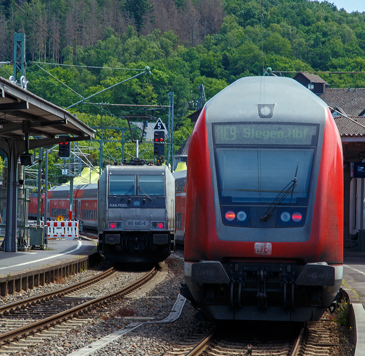 Bahnchaos in Betzdorf (Sieg)....
Die an die RTB CARGO GmbH vermietete 185 680-6 (91 80 6185 680-6 D-Rpool) der Railpool GmbH fährt am 17.06.2022 als Lz auf dem Gegengleis (Gleis 106) durch den Bahnhof Betzdorf (Sieg) nach Kirchen (Sieg), um einen liegengeblieben Güterzug abzuschleppen. Dafür bekommt sie das Signal Zs 1 – Ersatzsignal (drei weiße Lappen) gezeigt. So kann sie am Signal Hp 0 (oder am gestörten Lichthauptsignal) ohne schriftlichen Befehl vorbeifahren.

Rechts muss die 146 005-4 mit dem RE 9 (rsx - Rhein-Sieg-Express) nach Siegen, erstmal warten (fast eine halbe Stunde). Wobei es ist ja nicht mit der Verspätung eines Zuges getan, es baut sich dann auf viele Verbindungen auf. 