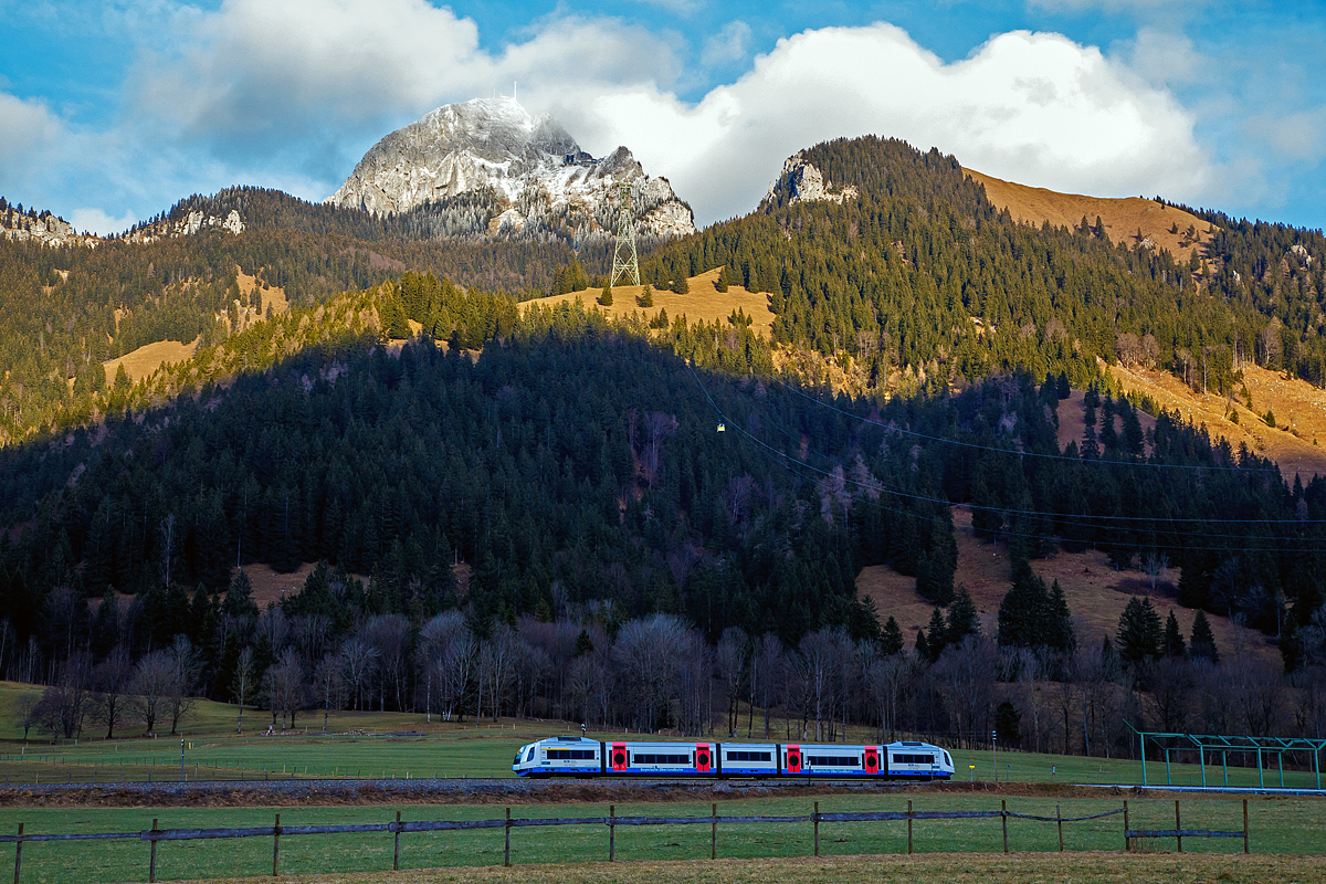 
Bayrischzell-Osterhofen (Oberbayern) am 28.12.2016: 
W�hrend der VT 117   Warngau   (95 80 0609 117-6 D-BOBy), ein Integral S5D95, der Bayerische Oberlandbahn GmbH (BOB), schon im Schatten, bald die Station Osterhofen (Oberbayern) erreicht, wird der 1.838 m hohe Wendelstein noch angestrahlt und dem Gipfel umh�llen noch einige Wolken. 

Die Wendelstein-Seilbahn f�hrt gerade auch, die gut zuerkennende Gondel 2 befindet sich gerade auf Talfahrt befindet.
Die Bergstation der Wendelstein-Seilbahn  befindet 1.724 m �ber NN, die Talstation auf 792 m. In 7 Minuten �berwindet sie damit einen H�henunterschied von 932 m, bei einer Streckenl�nge von 2.953 m.

Wir waren mit der Zahnradbahn oben. W�hrend hier unten sehr angenahme Plusgrade sind, so waren es oben minis 6 Grad.

