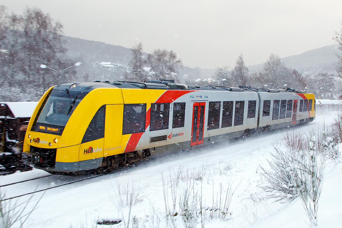 
Bei Schneefall....
Der VT 504 ein Alstom Coradia LINT 41 der neuen Generation (95 80 1648 104-5 D-HEB / 95 80 1648 604-4 D-HEB) der HLB (Hessische Landesbahn GmbH) fährt am 08.01.2017, als RB 96  Hellertalbahn  (Neunkirchen - Herdorf - Betzdorf), Umlauf 61776,  und erreicht bald den Bahnhof Herdorf.

Der LINT 41 wurde im Juli 2015 von ALSTOM LHB (Salzgitter) an die HLB für den Standort Siegen ausgeliefert. Eigentlich müssten diese LINT mit der neuen Kopfform ja LINT 42 heißen, da sie mit einer Länge von 42,17 m etwas länger sind als die ursprünglichen LINT 41 (41,81 m). Denn die Bezeichnung LINT 41 bedeutet „leichter innovativer Nahverkehrstriebwagen“, die 41 steht für die Länge der vollen Meter (bei dem ursprünglichen 41,81 m). Wird die Bezeichnung „H“ (LINT 41/H) verwendet, so sind es Hochflur-Fahrzeuge. Dies hier sind aber zweiteilige Niederflur-Dieseltriebwagen, welches man gut an der bis unten gehenden Tür erkennen kann.  

Die LINT-Triebwagen sind in Stahlbauweise ausgeführt. Bei den LINT 41 wird pro Wagenkasten ein Enddrehgestell von einer dieselmechanischen Antriebsanlage mit liegend eingebauten MTU-Reihen-Sechszylinder-Dieselmotoren mit  Leistung von 390 kW über eine Gelenkwelle angetrieben.

Bis zu drei Einheiten sind über automatische Scharfenbergkupplung Typ 10 zu einem Zug kuppelbar.

Als Bremsen werden druckluftbetätigte Scheibenbremsen verwendet, an je einem Triebdrehgestell befinden sich zusätzlich Magnetschienenbremsen. Als Feststellbremse sind Federspeicher vorhanden. Die Bremsanlagen ist von Knorr-Bremse. Die Fahrzeuge der HLB (wie auch die DB Regio) verwenden zudem Retarder als hydrodynamische Ergänzungsbremse. Die Fahrzeuge verfügen zusätzlich über Rußpartikelfilter.

Die Fahrzeuge verfügen über voneinander unabhängige Führerraumklimaanlagen und Fahrgastraumklimaanlagen. Je Wagenkasten sind zwei Dachklimageräte vorhanden. Die Abwärme der Dieselmotoren wird zur Beheizung von Fahrgasträumen und Führerräumen genutzt. Reicht die Abwärme nicht aus, so werden dieselbefeuerte Zusatzheizgeräte zugeschaltet. Geliefert wird die Heizungs-, Lüftungs-, Klimaanlage von „Spheros“ (ehemals Webasto).

Die Steuerschränke im Führerraum werden als Sonderlösung von Rittal produziert und von Alstom ausgerüstet.

Technische Daten:
Baureihenbezeichnung: 1 648 (anstelle der alten Ausführung 0 648)
Hersteller:	Alstom Transport Deutschland GmbH
Spurweite: 1.435 mm (Normalspur)
Radsatzfolge: Bx’ (2) By’
Länge: 42,17 m
Breite: 2.750 mm
Drehzapfenabstand: 16.500 mm
Drehgestellachsstand (Antriebsgestelle): 1.900 mm
Drehgestellachsstand (Jakobsgestell): 2.700 mm
Eigengewicht: 76,3 t
Geschwindigkeit: 140 km/h
Leistung: 2 x 390 kW
Fahrgastsitzplätze: 8 in der 1. Klasse und 94 in der 2. Klasse
Niederfluranteil: 60 %
Kupplungstyp: Scharfenbergkupplung Typ 10
Fahrzeugbestand der HLB: 7

