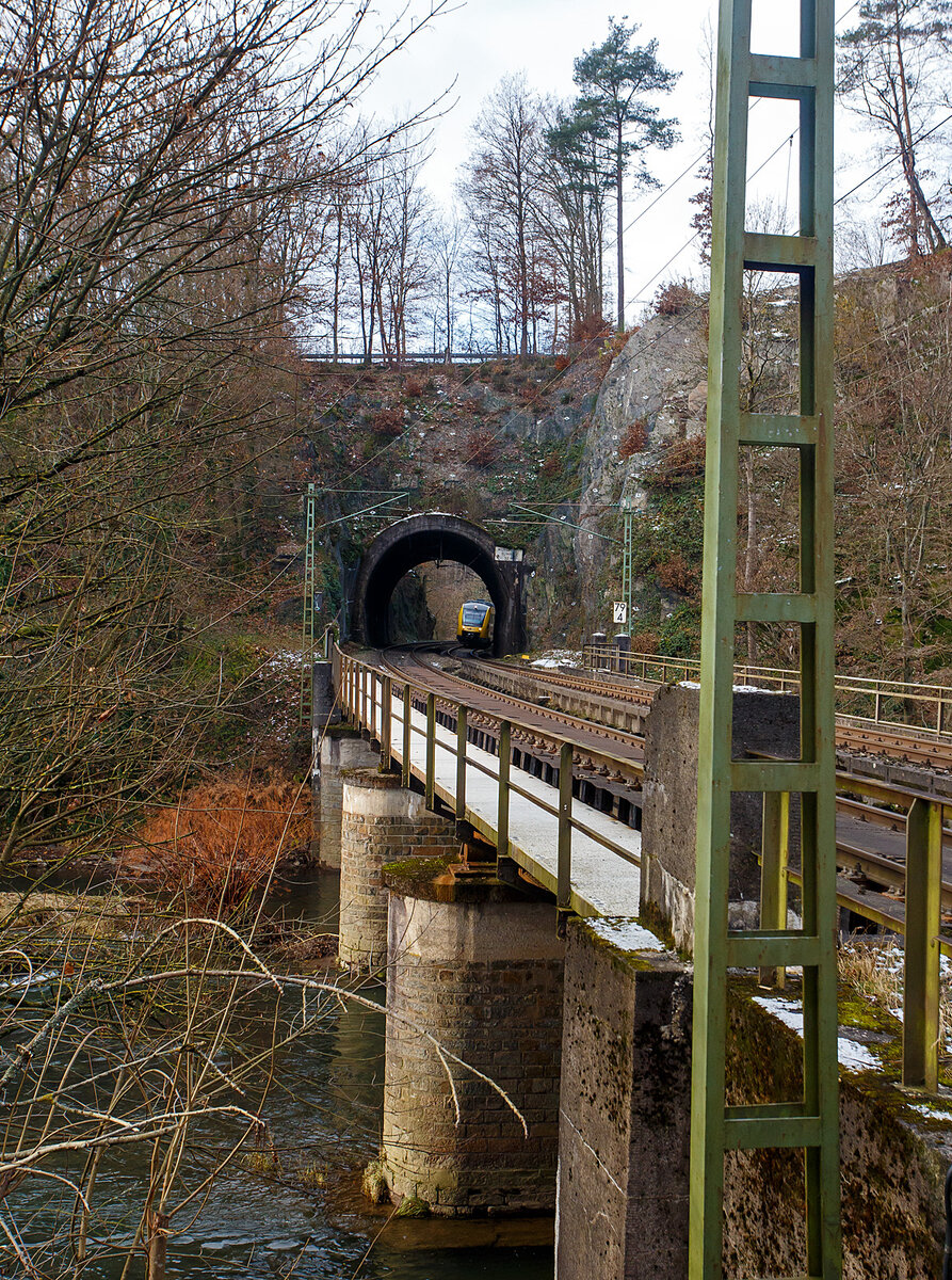 Beim Wiederlager der Siegbrücke beim Bahnhof Scheuerfeld (Sieg) mit dem Blick über die Siegbrücke zum 32 m langen Mühlburg-Tunnel der Siegstrecke (KBS 460) bei km 79,4 am 02.12.2023. Hinten kommt der VT 256 (95 80 0648 156-7 D-HEB / 95 80 0648 656-6 D-HEB), ein Alstom Coradia LINT 41 der HLB - Hessische Landesbahn (3LänderBahn), als RB 90 „Westerwald-Sieg-Bahn“ , der Verbindung Altenkirchen(Westerwald) – Au(Sieg) - Betzdorf(Sieg) – Siegen Hbf.