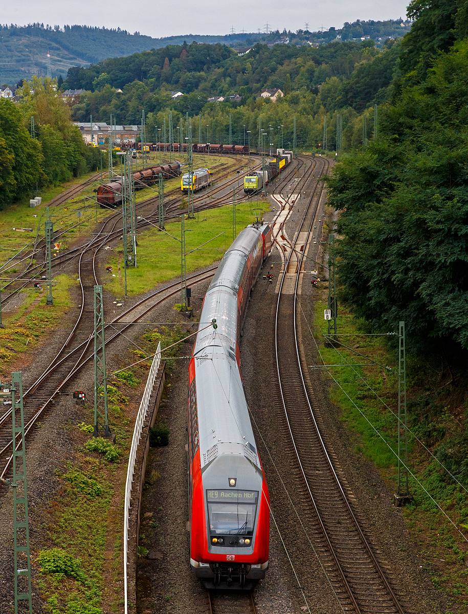 Blick auf den Rangierbahnhof (Rbf) Betzdorf/Sieg (von der Brücke in Betzdorf-Bruche)........
Der RE 9 hat am 20.09.2021 den Bahnhof Betzdorf (Sieg) verlassen und fährt Steuerwagenvoraus weiter in Richtung Köln.

Hinten im Rbf hat die α 185 603-8 (91 80 6185 603-8 D-ATLU) einen leeren Güterzug abgestellt. 