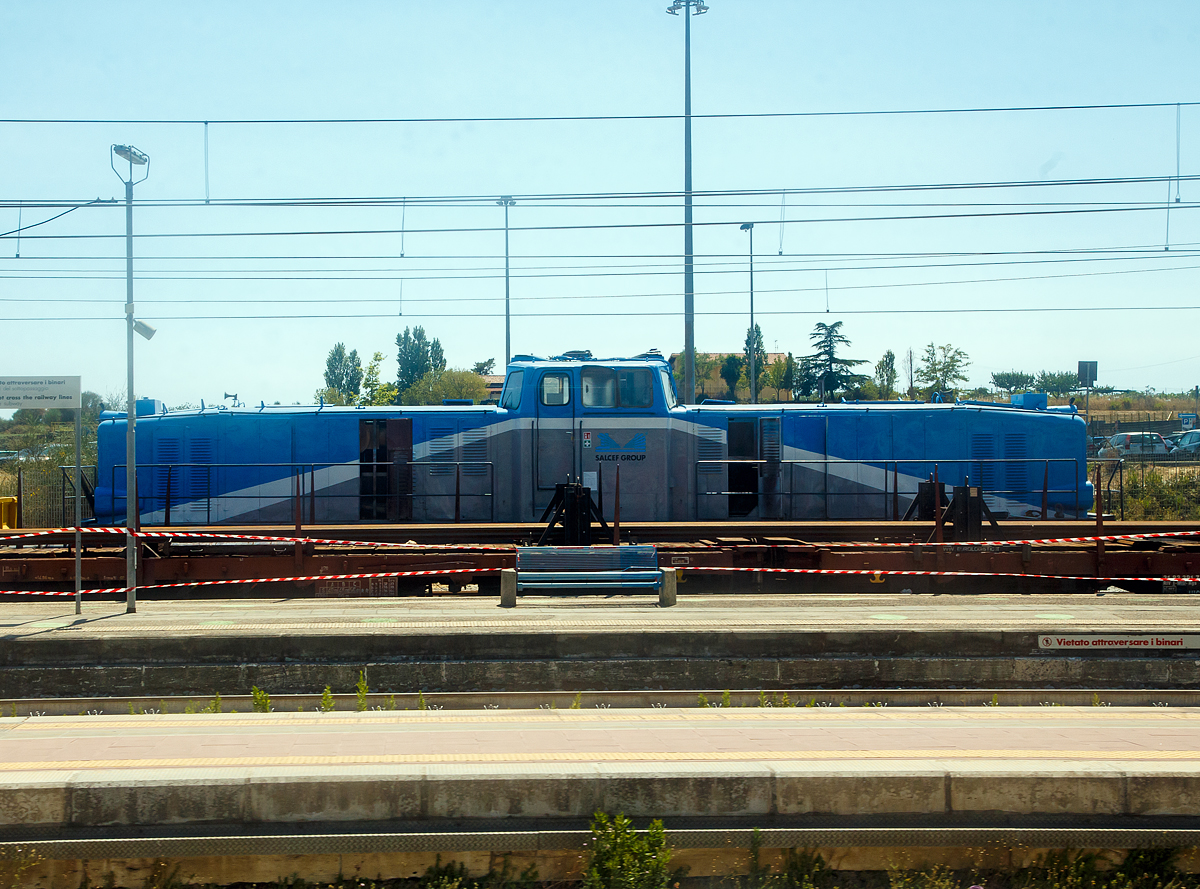 Da staunt man nicht schlecht, wenn einem in Italien so ein deutscher Lok-Oldtimer �ber den Weg l�uft....

Eine Deutz DG 1600 BBM der Salcef Group S.p.A. abgestellt am 14.07.2002 beim Bahnhof Campoleone (s�dlich von Rom), aufgenommen aus einem fahrenden IC. 

Die Lok ist eine der beiden ex WLE Loks die1988 nach Italien verkauften Lok von diesem Typ (Fabriknummer 56595 oder 56596, Baujahr 1957). Die Lok sieht m�chtiger aus als sie ist.

Von den Diesellokomotiven vom Typ DG 1600 BBM des Herstellers Kl�ckner-Humboldt-Deutz (KHD), aus dem Typenprogramm von 1954 wurden nur drei St�ck gebaut. Um die Leistung einer Lokomotive zu vergr��ern waren damals zwei Motoren erforderlich, weil st�rkere Motoren noch nicht verf�gbar waren. Da eine Lokomotive mit Drehgestellen bessere Laufeigenschaften hat, entstanden bei KHD 1957 drei Lokomotiven mit zwei Motoren, die jeweils auf ein Drehgestell wirkten.

Zwei Lokomotiven wurden an die Westf�lische Landes-Eisenbahn (WLE) verkauft und sollten dort schwere G�terz�ge �ber den Haarstrang ziehen. Lediglich auf dem steilsten Abschnitt war noch eine Schiebelokomotive erforderlich. F�r diesen Einsatz bew�hrten sich die Lokomotiven hervorragend, bei einer Steigung von 20 ‰ konnte eine Lokomotive eine Last von 600 t schleppen. Daraufhin wurde die dritte Lokomotive der Baureihe, die zwischenzeitlich an die Osthannoverschen Eisenbahnen vermietet war, von der WLE �bernommen. Die Lokomotiven wurden als WLE VL 0631–0633 bezeichnet. Die Lokomotiven waren bis weit in die 1980er Jahre im Einsatz. Vorrangig wurden sie im schweren G�terzugdienst verwendet, aber auch im Personenzugdienst waren sie zu sehen. Die Lokomotiven VL 0632 und VL 0633 wurden 1988 an eine Bauzugfirma in Italien verkauft. Die VL 0631 wurde 1996 abgestellt.

Die Lokomotiven entstanden nach der KHD DG 2000 BBM von 1956 und waren seinerzeit die gr��ten Vorbautenlokomotiven mit Mittelf�hrerstand in Deutschland. In den beiden Vorbauten war je eine Maschinenanlage untergebracht, die das jeweilige Drehgestell antrieben. Je nach Bedarf konnte mit zwei oder mit einem Motor gefahren werden.

Sie waren mit zwei luftgek�hlten Zw�lfzylinder-Zweitakt-Dieselmotoren (Typ T 12 M 625) ausger�stet, die ihre Leistung an ein Str�mungsgetriebe von Voith abgaben. Der Dieselmotor war im Vorbau vorne angeordnet, das Str�mungsgetriebe war in der N�he des F�hrerhauses untergebracht. Von dort erfolgte die Kraft�bertragung zur Drehgestellmitte. �ber ein Zwischengetriebe wurden die beiden Rads�tze �ber Gelenkwellen angetrieben.

TECHNISCHE DATEN (bei Auslieferung):
Spurweite: 1.435 mm (Normalspur)
Achsformel: B'B'
L�nge �ber Puffer: 17.200 mm
Drehzapfenabstand: 10.400 mm
Achsabstand im Drehgestell: 3.100 mm
Treibraddurchmesser: 1.050 mm (neu)
Leergewicht: 76.000 kg
Dienstgewicht: 80.000 kg
H�chstgeschwindigkeit: 	70 km/h
Installierte Leistung: 2 � 588 kW (2 x 800 PS = 1.600 PS) 
Motorentyp: KHD T 12 M 625
Motorbauart: luftgek�hlter 12-Zylinder-Zweitakt-Dieselmotor
Nenndrehzahl: 750 U/min
Getriebe: Voith L306r
Leistungs�bertragung: hydraulisch
Kleinster bef. Halbmesser: 80 m
Tankinhalt: 2.200 l
Bremse: Indirekte Bremse Bauart Knorr
