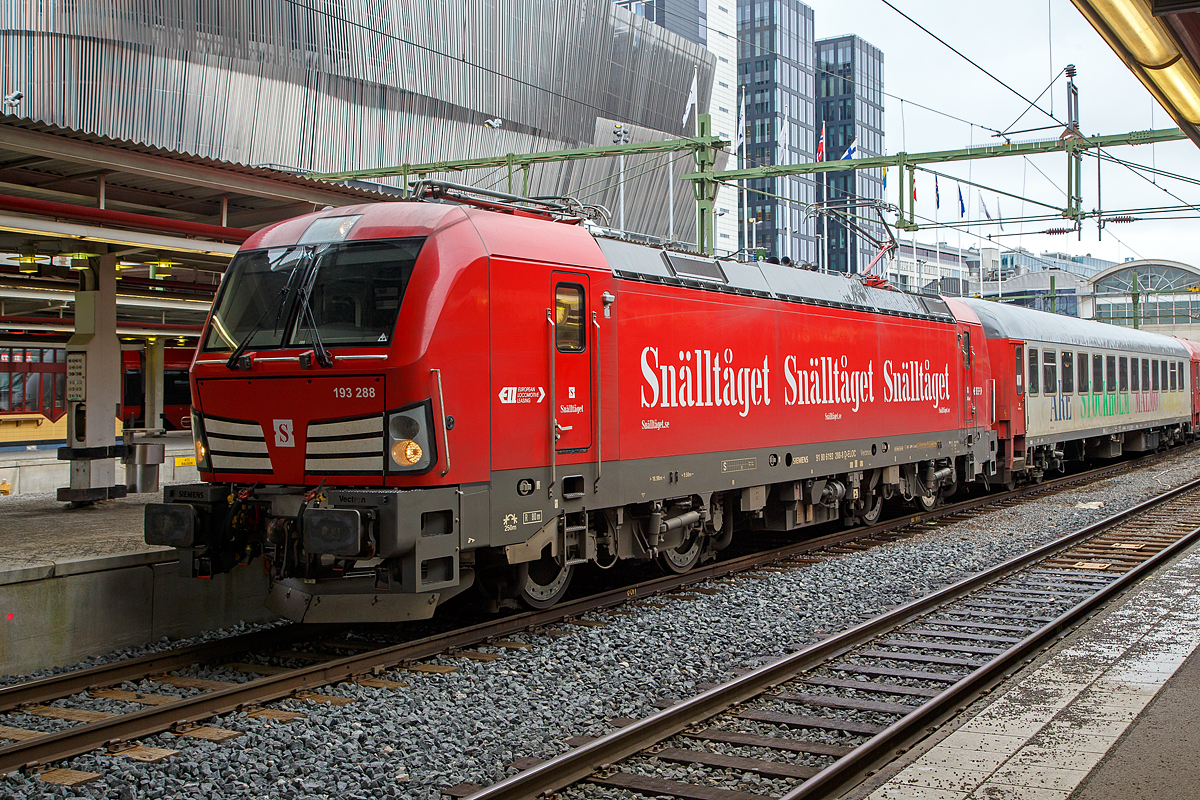 Das verstehe wer will, in Deutschland registriert (D-ELOC), aber nicht in Deutschland zugelassen, sondern nur in Schweden und Norwegen.....

Die an Snälltåget (ein Unternehmen Transdev Sverige AB) vermietete Siemens Vectron AC 193 288-8 (91 80 6193 288-8 D-ELOC) der ELL - European Locomotive Leasing, erreicht am 21.03.2019, mit dem einem Snälltåget Nachtzug Åre-Stockholm-Malmö, Stockholm Central (Hauptbahnhof).

Die Siemens Vectron AC (6,4 MW) wurde 2018 von Siemens Mobilitiy in München unter der Fabriknummer 22256 gebaut. Sie hat die Zulassung für Schweden und Norwegen und ist an die Transdev Sverige AB vermietet. 

Die Reisezugwagen sind für 200 km/h zugelassene ehemalige DB UIC-X-Wagen (Schnellzugwagen). Die Wagen sind Eigentum von Snälltåget AB, sind aber in Österreich registriert (A-SNALL). Hier hinter der VECTRON ist der Wagen 11 der A-SNALL 61 81 22-90 064-9  Bmpz, dieser wurde 1979 von der Wagon Union (WU) in Berlin-Borsigwalde als D-DB 51 80 22-90 247-3 Bm 235 für die DB gebaut. Später ging er als B12 ICK-Reisezugwagen (50 84 22-37 991-9) an die NS und wurde 2013 an die Hector Rail nach Schweden verkauft, 2017 ging er an die Snälltåget.

Die Snälltåget ist ein schwedisches Eisenbahnunternehmen und gehört zur Transdev Sverige AB. Sie betreibt in Schweden Fernzüge. Die Hauptstrecke (Södra stambanan) wird ganzjährig von Malmö nach Stockholm betrieben. In der Wander- und Skisaison betreibt Snälltåget Nachtzüge nach Åre und Storlien. In den Sommermonaten verkehrt auch ein Nachtzug von Malmö nach Berlin. Bis 2019 fuhr man den „Berlin-Night-Express“ mit Fährverbindung zwischen Sassnitz und Trelleborg über die sogenannte „Königslinie“. Seit 2021 verkehrt der Nachtzug „Berlin-Night-Express“ ohne Fähre (Trajektierung) über den Großen Belt, sowie den Öresund nach Stockholm. Dadurch werden nun neu auch Kopenhagen und Hamburg angebunden.