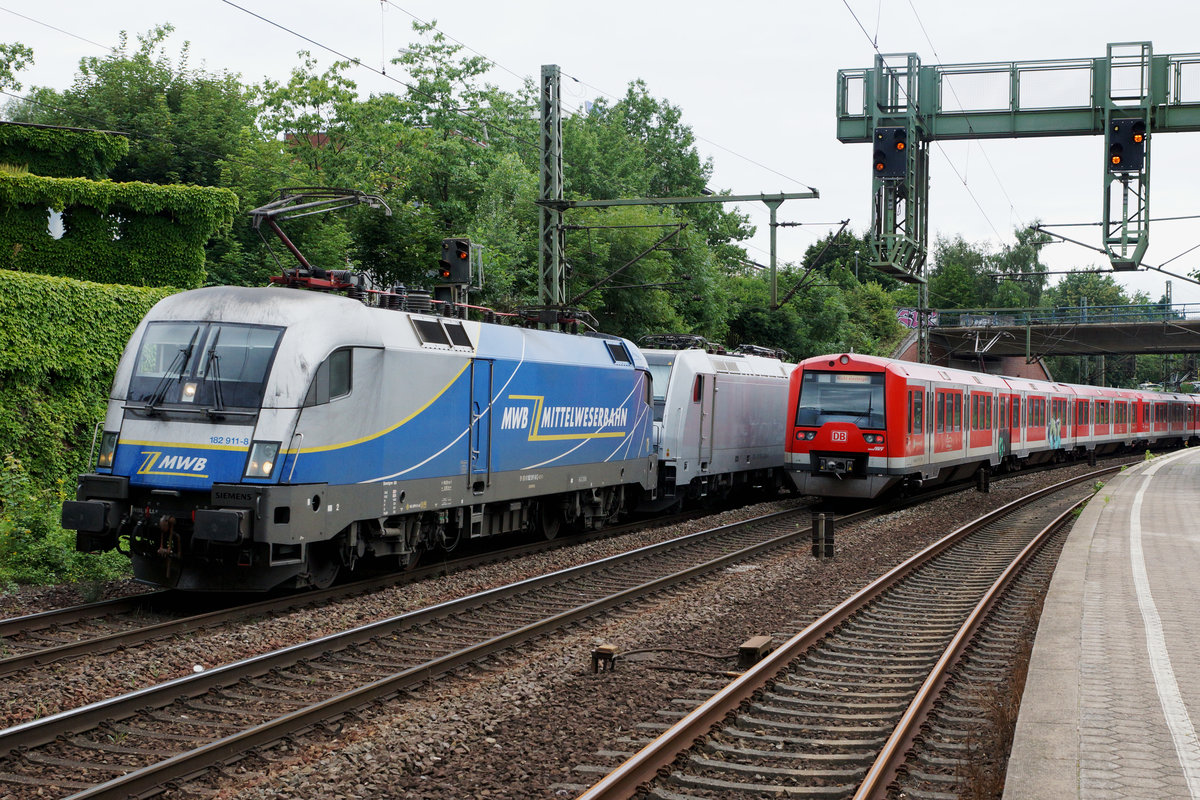 DB/MWB: Die 182 911-8 der Mittelweserbahn anlässlich einer seltenen Begegnung vom 9. August 2016 mit einer S-Bahn in Hamburg Harburg.
Foto: Walter Ruetsch