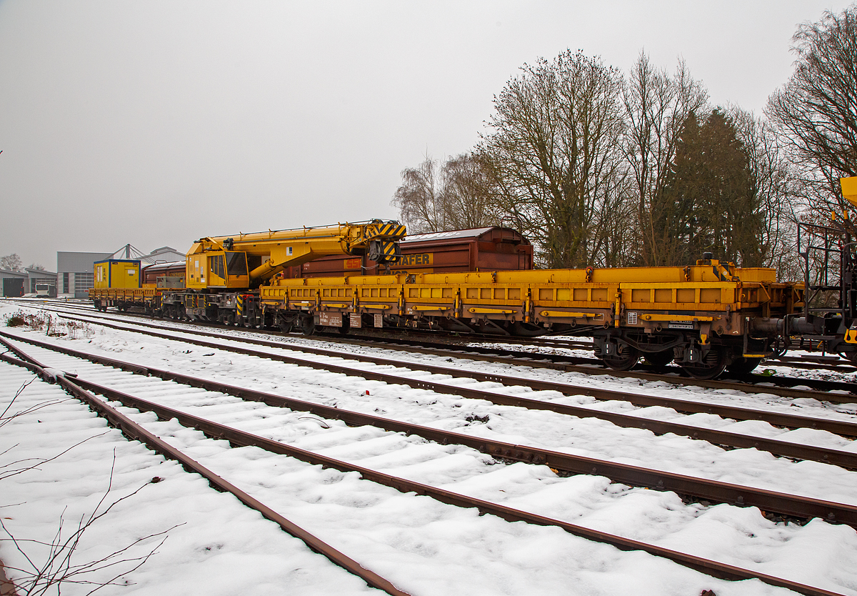 Der 125 t KIROW Gleisbauschienenkran KIROW Multi Tasker KRC 810 T (mit Schwerlastausr�stung), Schweres Nebenfahrzeug Nr. D-HGUI 99 80 9419 024-1, ex 97 82 53 513 19-3, der HERING Bahnbau GmbH (Burbach) ist am 11.12.2021 auf dem Betriebshof der Westerwaldbahn (WEBA) auf der Bindweide bei Steinebach/Sieg abgestellt. Davor der 4-achsiger Drehgestell-Flachwagen, 37 80 3999 048-6 D-HGUI, der Gattung Res als Schutzwagen auslegerseitig (u.a. beladen mit der Traverse) zum KRC 810 T. Und dahinter der 4-achsiger Drehgestell-Flachwagen, 37 80 3999 049-4 D-HGUI, als Schutzwagen gegenlastseitig zum KRC 810 T.

Der Kran wurde 2008 von KIROW in Leipzig unter der Fabriknummer 149000  gebaut und an die HERING Bahnbau GmbH (Burbach) geliefert.
