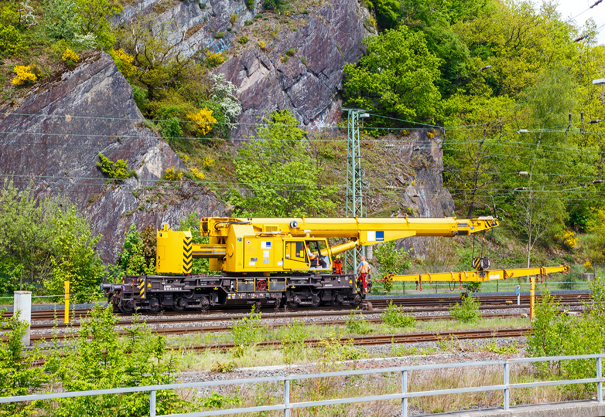 
Der 125t - KIROW Gleisbauschienenkran KRC 810 T der Hering Bau (Burbach), Schweres Nebenfahrzeug Nr. D-HGUI 99 80 9419 010-0, fährt am 09.05.2015, nach dem Ablegen einer Weiche im Hbf Siegen, nun wieder Rückwärts zum Lagerplatz um das nächste Teil zu holen.

Der Kran wurde 2013 von KIROW in Leipzig unter der Fabriknummer MT2012170324 gebaut und an die Hering Bau geliefert. Die Hering Bau gehört in Deutschland zu den größten Eisenbahnkran-Dienstleistern, sie hat 10 eigene Krane.

Der 125-t-Eisenbahndrehkran wird für den Aus-und Einbau von schweren Betonweichen, Gleisjochen und Hilfsbrücken sowie für die Montage von Ingenieurbauwerken eingesetzt. Bei Havarien auf Bahnstrecken leistet er schnelle Hilfe zum Bergen schwerer Lasten.

Technische Daten
Eigengewicht: 128 t
Länge über Puffer: 13.000 mm
Achsanzahl: 8
Drehzapfenabstand: 8.000 mm
Drehzapfenabstand im Drehgestell 1 und 2: 2.300 mm
Achsabstand in den Einzeldrehgestellen: 1.100mm
Ergebene Achsabstände in m: 1,1 / 1,2 / 1,1/ 4,6 / 1,1 / 1,2 / 1,1
Achsfolge: 1'A'1A'A1'A1'
Achslast: 16,0 t
Motorleistung: 235 kW
Fahrgeschwindigkeit im Zugverband: 100 km/h
Fahrgeschwindigkeit mit Eigenantrieb: 19 km/h
zul. Anhängelast: -
Zugelassen als Schwerwagen für Streckenklasse: CS 05
kleinster befahrbarer Radius: 00 m

Tragfähigkeiten:
bei 0,00 m Ausladung vor Puffer, mit Schwerlastausrüstung: 125 t
bei 2,80 m Ausladung vor Puffer, ± 30°, abgestützt: 90 t
bei 2,80 m Ausladung vor Puffer, ± 20°, freistehend: 46 t