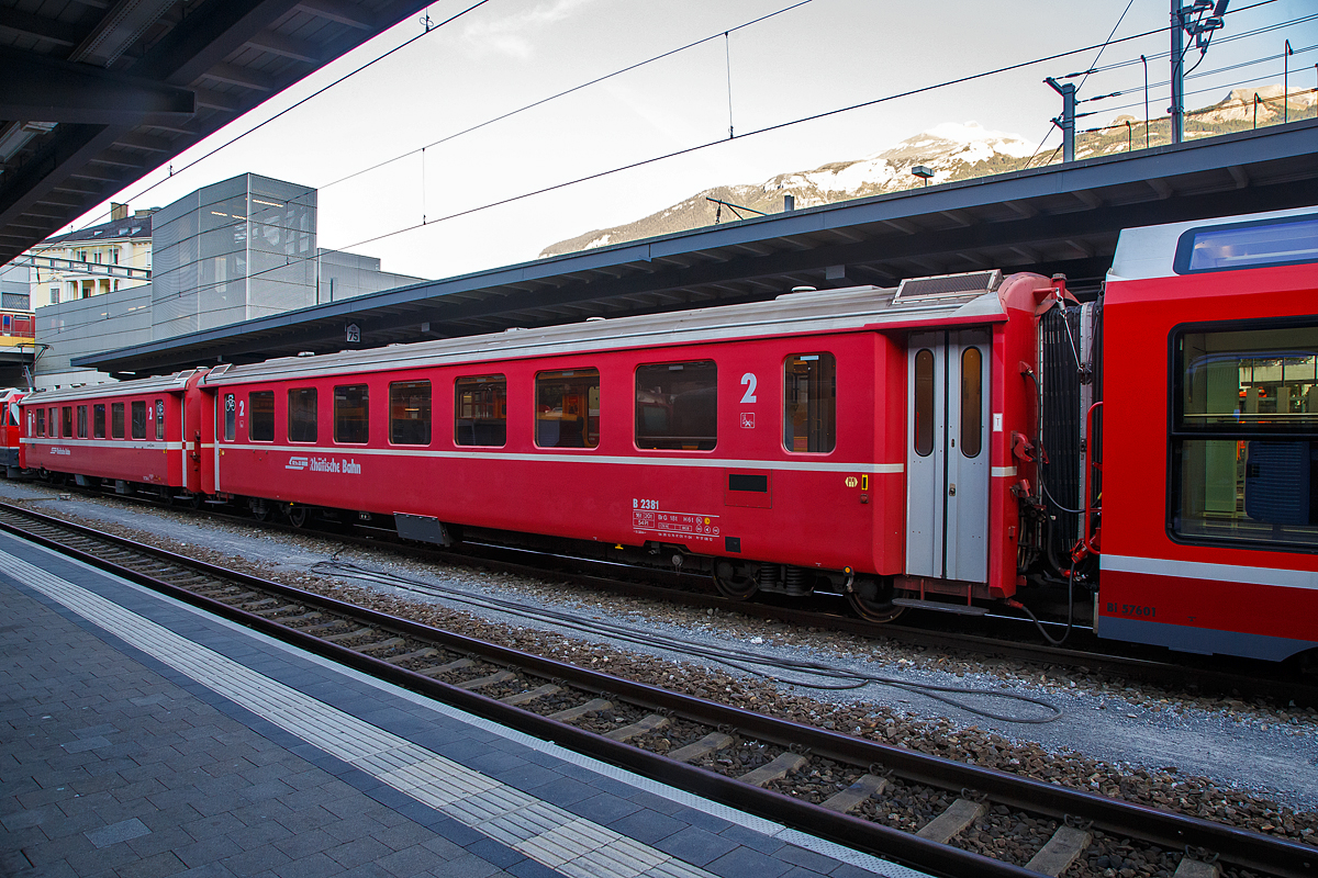 Der 4-achsige Personenwagen RhB B 2381, ein langer  2.Klasse Einheitswagen II (FFA EW II) mit Aluminiumwagenkasten am 06.09.2021 im Zugverband im Bahnhof Chur.

Gestiegene Fahrgastzahlen und Komfortanspr�che veranlassten die RhB, das bew�hrte Konzept des Einheitswagen I nach etwa einem Jahrzehnt zu �berarbeiten und den sogenannten Einheitswagen II (EW II) mit der Industrie zu entwickeln. Mehr als 60 Fahrzeuge dieser Serie konnten �ber einen Zeitraum von acht Jahren beschafft werden.  Von diesen 2.Klasse Wagen in der langen Ausf�hrung waren es alleine 40 St�ck (B 2374–83, 2421–50)

Als Verbesserung gegen�ber den EW I gelten neue Drehgestelle vom Typ SWP 74, der vergr��erte Sitzteiler (1.780 mm) in der 2. Klasse, get�nte Doppelverglasung und ein verbessertes Heizungs- und L�ftungssystem (�Hagenuk�). Trotz neuer Stoffbez�ge in der zweiten Wagenklasse, die Anfang der neunziger Jahre die roten und gr�nen Kunststoffsitzbez�ge abgel�st haben, wirkt das Interieur dieser Fahrzeuge heute gegen�ber den modernisierten EW I etwas altmodisch. Folgerichtig hat die RhB mit einem umfangreichen Refit-Programm begonnen. Neben einem modernen geschlossenen Toiletten-System erhalten diese Wagen, Dachklimager�te, ein neues Fahrgast-Informationssystem mit Innen- und Au�enanzeigen. Ferner wird die Inneneinrichtung zeitgem�� gestaltet.

TECHNISCHE DATEN:
Baujahre: 1976 bis 1980 (dieser 1976, Umbau 2004)
Hersteller:  Flug- und Fahrzeugwerke Altenrhein AG (FFA)
Hersteller Drehgestelle: Schindler Waggon Pratteln (SWP) 
Spurweite: 1.000 mm
Anzahl der Achsen: 4
L�nge �ber Puffer: 18.500 mm
Drehgestellbauart: SWP 74
Sitzpl�tze: 54 (2.Klasse)
Eigengewicht: 16,0 t
Max. Gesamtgewicht: 20 t
zul�ssige Geschwindigkeit: 90 km/h
Lauff�hig: StN (Stammnetz) / MGB (Matterhorn Gotthard Bahn)

Auf der Berninabahn ist ein Einsatz dieser langen Wagen nicht m�glich. Diese w�rden dort bedingt durch die teilweise engeren Gleisb�gen entgleisen.
