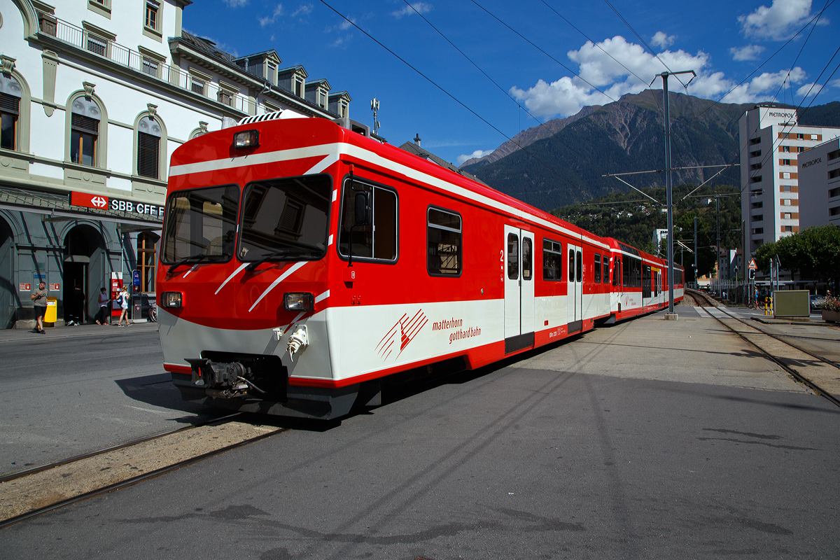 Der „KOMET“ MGB ABDeh 4/8 2027 ein Stadler Niederflur-Panoramatriebzug mit Zahnrad- und Adh�sionsantrieb f�hrt am 07.09.2021, mit vorangestellten Niederflur-Steuerwagen BDkt 2233 () als Regionalzug (R 43) nach Visp, in den Bahnhof Brig ein.

Der Niederflur-Steuerwagen BDkt 2233 ist ein sogenannter Kofferkuliwagen der ehem. Brig-Visp-Zermatt-Bahn (BVZ). Er wurde 1990 von Stadler, SWS und BBC gebaut, 2015 erfolgte in Umbau und Anpassung an die KOMET-Triebz�ge durch Stadler.

Wegen des Fahrverbots auf der Stra�e T�sch–Zermatt brauchte man f�r die Shuttle-Z�ge zus�tzlichen Gep�ckraum. Deshalb entwickelte die BVZ zusammen mit Stadler einen Kofferkuliwagen, dessen Mittelteil so weit abgesenkt war, damit vom Perron her durch breite T�ren in diesen Niederflurteil mit den Kofferrolliwagen eingefahren werden konnte. Die Sitzpl�tze �ber den Drehgestellen waren gegen die Zugmitte gerichtet, sodass jeder Fahrgast sein Gep�ck �berwachen konnte.

Die Wagen sind in Stahl/Aluminium-Mischbauweise aufgebaut und laufen auf modernisierten SWS-Drehgestellen von Holzkastenwagen. Bis 1990 wurden insgesamt 6 Wagen, die H�lfte davon Steuerwagen, gebaut (2231–2233, 2235–2237). Seit der Ablieferung von vier Triebz�gen (BDSeh 4/8 2051–54) f�r den Shuttle-Verkehr, dienen noch drei Wagen als Reserve, die anderen drei sind als Velotransportwagen f�r das Goms adaptiert worden.

die drei Steuerwagen durch Stadler f�r den Betrieb mit den Triebz�gen vom Typ KOMET (2011–14, 2021–28, 2051–54, 2131–34) angepasst und werden f�r den Gep�ck- und Velotransport sowie als Reserve f�r die Shuttle-Z�ge T�sch–Zermatt eingesetzt. Die drei Zwischenwagen 2235–37 verkehren als Velowagen im Goms.

TECHNISCHE DATEN des BDkt (Steuerwagen):
Anzahl Fahrzeuge: 3 St�ck (BDkt 2231 - 33)
Spurweite:  1.000 mm
Achsanordnung: 2‘2‘
L�nge �ber Kupplung: 
Leergewicht: 19,5 t
Dienstgewicht (max.): 26,7 t
Sitzpl�tze: 29 (2.Klasse)
Stehpl�tze: 63
Ladefl�che: 21 m�
H�chstgeschwindigkeit: 80 km/h