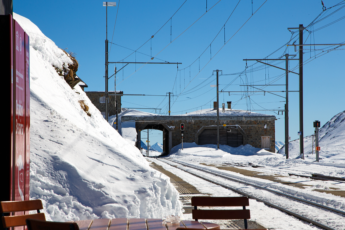 Der Bahnhof Ospizio Bernina (Bernina Hospiz) am 18.02.2017, Blickrichtung S�den. Links die Durchfahrt weiter in Richtung Alp Gr�m, rechts die Remise mit Drehscheibe f�r die Schneeschleuder. 