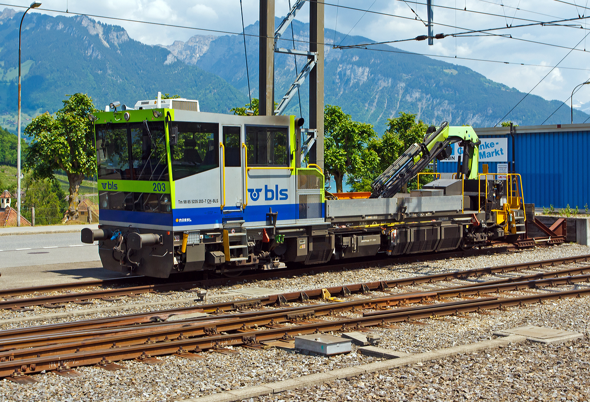 Der BLS Bautraktor Tm 235 203-7 (Tm 98 85 5235 203-7 CH-BLS), ein BLS SIF (St�rungsinterventionsfahrzeuge) Typ C bzw. Robel Gleiskraftwagen mit PALFINGER-Kran PK 20002 D 20mt (Baujahr 2007), abgestellt am 28.05.2012 beim Bahnhof Spiez (aufgenommen aus einfahrendem Zug). 

BLS Anforderungen an die St�rungsinterventionsfahrzeuge im Einsatz sind u.a.:
Modernstes Partikelfiltersystem f�r problemlosen Einsatz speziell im Tunnelbereich.
Funkfernsteuerung f�r den Baustelleneinsatz inkl. Kranbedienung (V = 0 bis10 km/h), z. B. f�r Verf�llarbeiten von Schotter.
Transport von Baumaterial und Ger�ten zur Baustelle.
Schienenladeeinrichtung f�r den Transport von zwei 13 m-Schienen.
Leistungsf�higer Ladekran mit gro�er Reichweite, je nach Typ teilweise ausger�stet mit Arbeitskorb f�r die Instandhaltung der Oberleitung.
Gro�e Kabine mit Standheizung und Temperatur-Absenkanlage,  Sitzpl�tze f�r 7 Personen (1 Fahrer, 6 Beifahrer).

TECHNISCHE DATEN: 
Spurweite: 1.435 mm 
Achsfolge: B
L�nge �ber Puffer: 14.396 mm
Achsabstand: 9.000 mm
Treibraddurchmesser: 920 mm (neu)
Gesamtbreite: ca. 3.160 mm
L�nge der Ladefl�che: 5.500 x 2.700 mm
Eigengewicht: 32 t
Zuladung: 5 t
Minimaler Kurvenradius: R 80 m
H�chstgeschwindigkeit (hydrodynamisch): 100 km/h 
H�chstgeschwindigkeit (hydrostatisch): 10 km/h
H�chstgeschwindigkeit (geschleppt): 100 km/h
Motorart und -type: 2 St�ck wassergek�hlter V6-Zylinder-Dieselmotor mit Turboaufladung, Ladeluftk�hlung und Vierventiltechnik vom Typ DEUTZ TCD 2015 V6 4V
Hubvolumen je Motor: 11,9 l (Bohrung � 132 mm x Hub 145 mm)
Leistung (an der Welle): 2 � 330 kW = 660 kW
Nenndrehzahl: 2.100 U/min (min Leerlaufdrehzahl 600 U/ min)
Motorgewicht (trocken): 1.020 kg 
Abgas-Emissionswerte:  gem�� RL 97/68/EG Stufe IIIA
Antriebsart: Diesel – Hydrodynamisch
Turbogetriebe: 2 x VOITH T211
Anfahrzugkraft: 100 kN
Max. Anh�ngelast: 2.600 t
Bremse:  IE-GP-hd mZ, Fs, Dynamische Bremse (Retarder VOITH)
Stromerzeuger f�r externe Verbraucher:  13 kVA, 400 V
Sicherheitseinrichtungen: SIGNUM Integra /

Reichweite vom Kran (PK 20002D) bis 14,7 m (Tragkraft 910 kg), bei 4,3 m Ausladung liebt die Tragkraft bei 4.000 kg.
