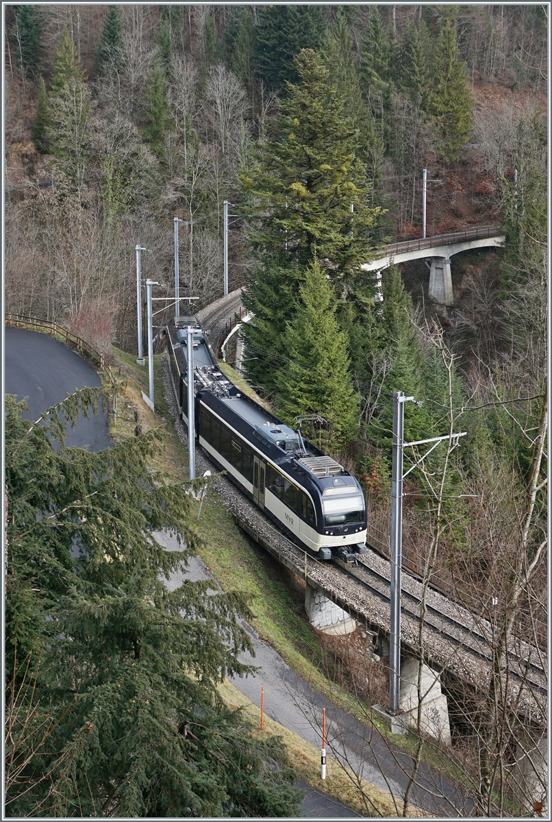Der CEV MVR ABeh 2/6 7501 ist auf der Fahrt von Montreux nach Les Avants und ist bei der Pont Gardiol angelangt. Die Brücke ist 93 Meter lang und überbrückt den Bois des Chenaux. 

4. Januar. 2023